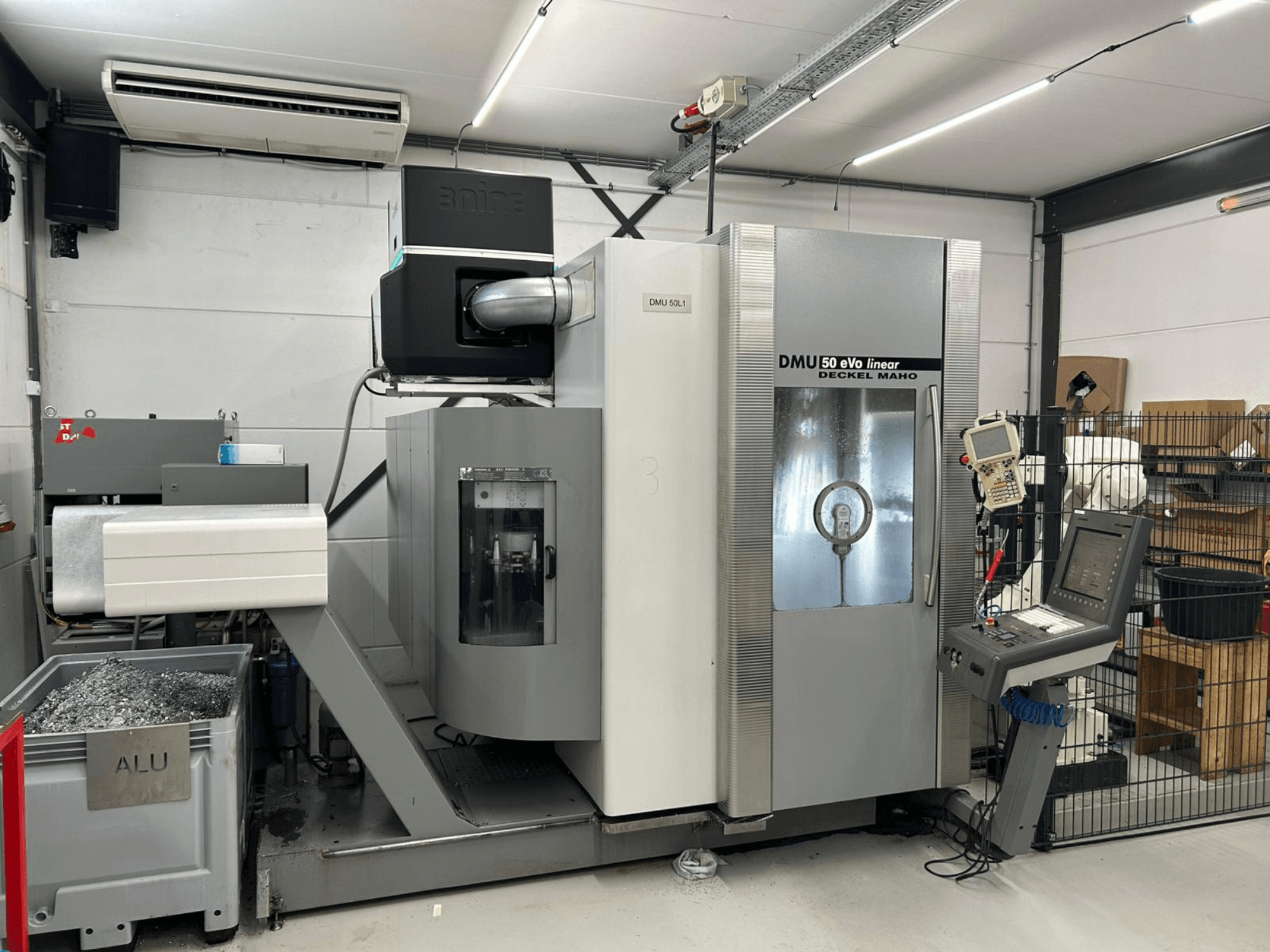 Линейно-фрезерный станок DMU 50 eVo производства Deckel Maho, вид спереди, с панелью управления и контейнером для стружки.