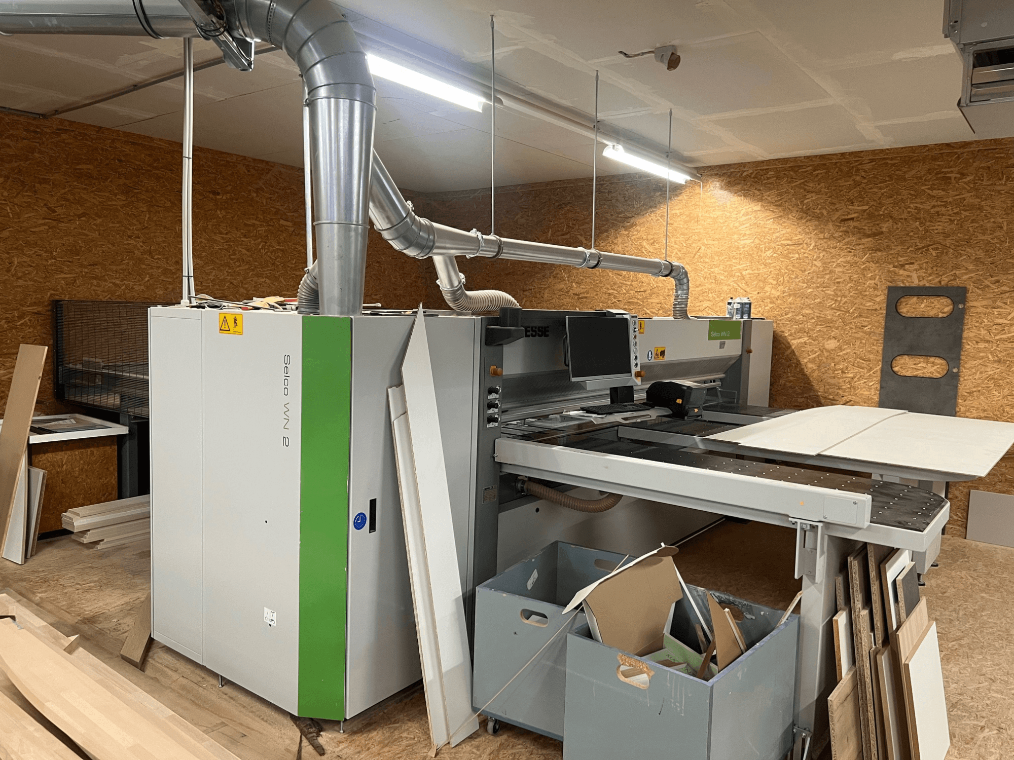 Панельная пила BIESSE Selco WN 2 в мастерской, с большим режущим столом и системой пылеудаления, вид сбоку.