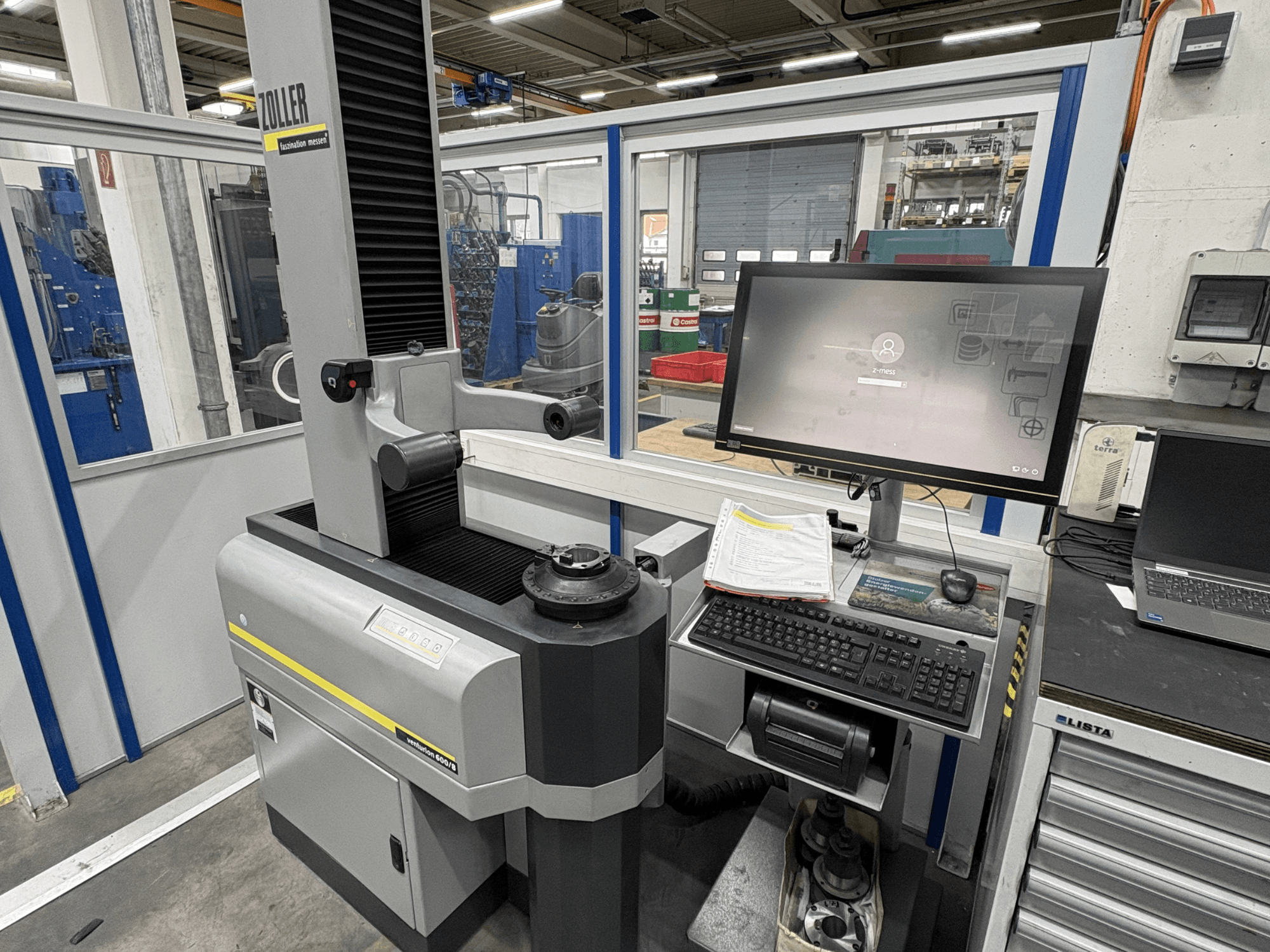 Оптическая измерительная машина Zoller Venturion 600/8 в мастерской, с монитором, клавиатурой и измерительной платформой (вид сбоку).