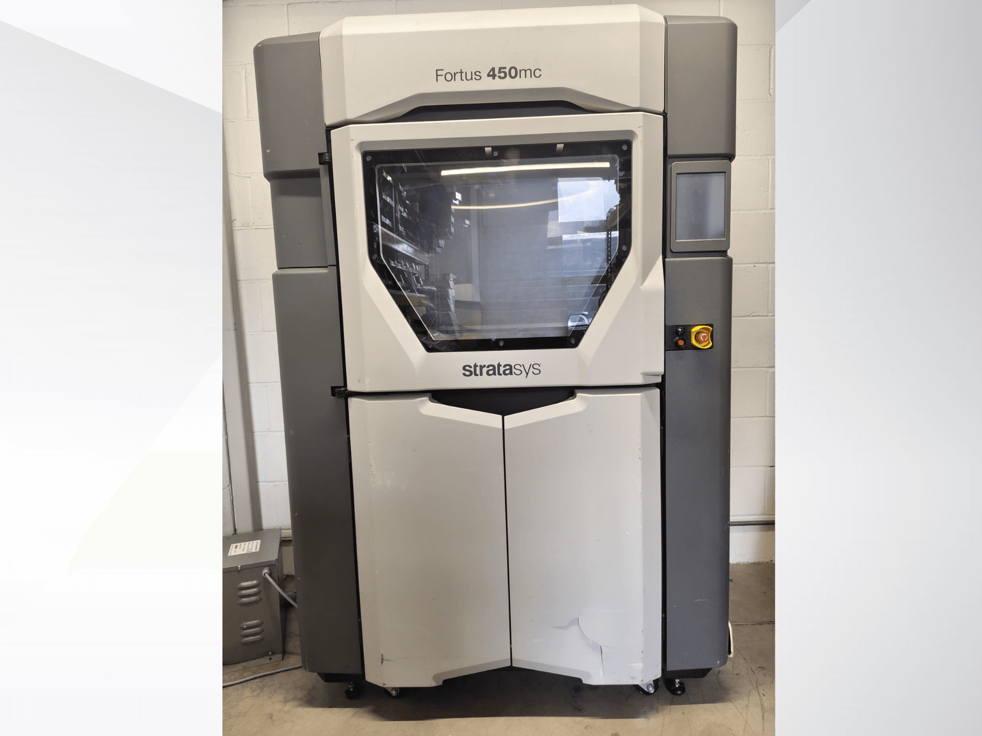 Машина для обработки пластика Stratasys Fortus 450mc, вид спереди, с большим смотровым окном, панелью управления и промышленным дизайном.