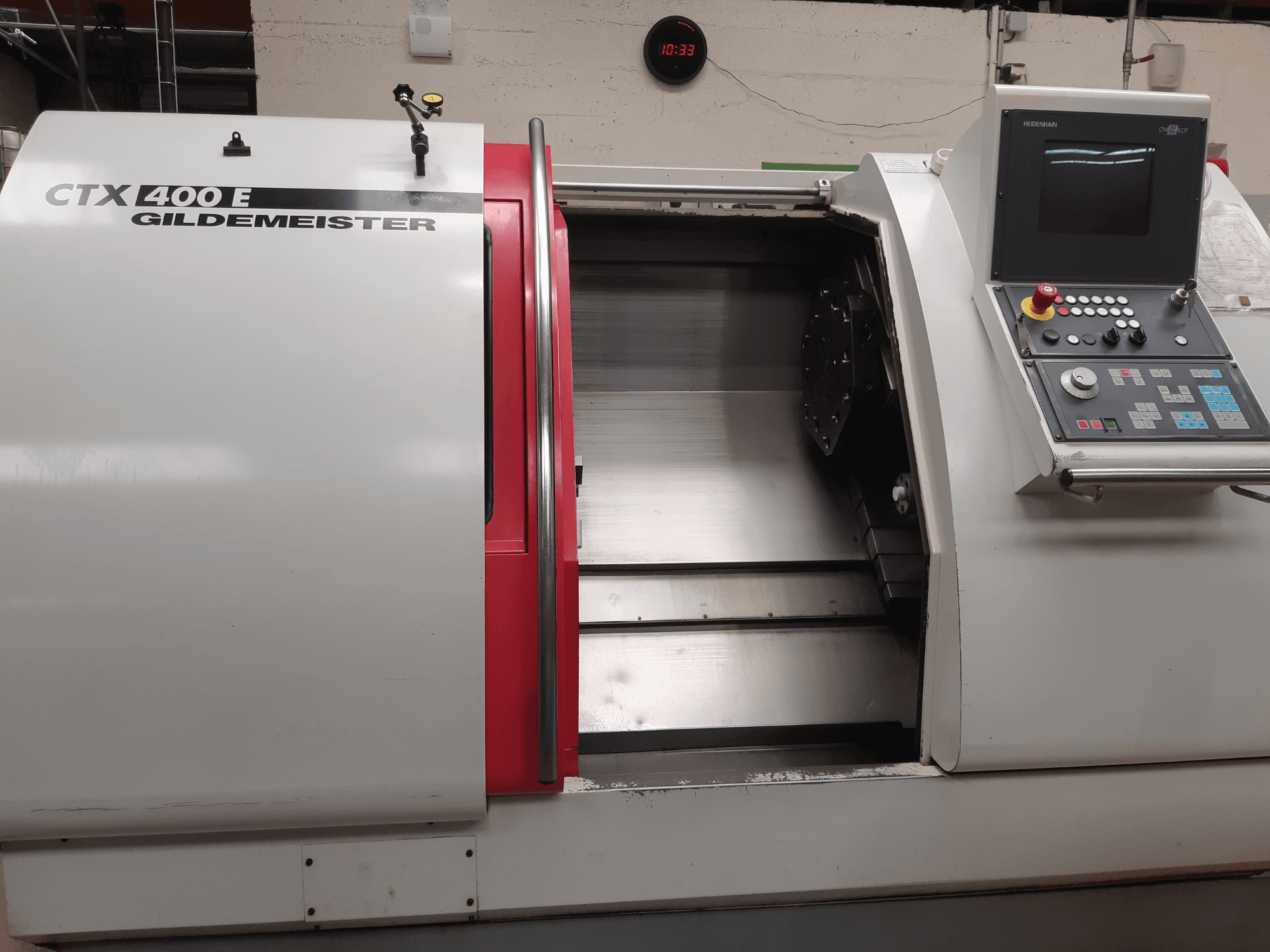 Горизонтальный токарный станок Gildemeister CTX 400 E, сфотографированный под углом, с видом на панель управления и открытый передний отсек для доступа к инструментам.
