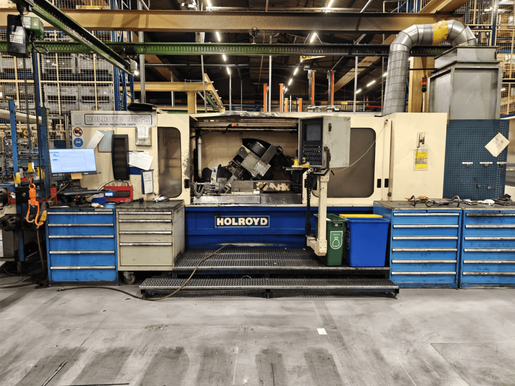 Станок Holroyd 3EX-R в мастерской, вид спереди, видна панель управления, хранилище инструментов и рабочая зона внутри.