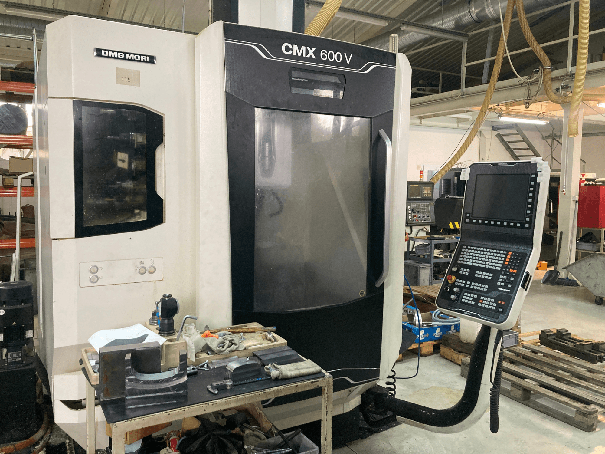 Фрезерный станок DMG MORI CMX 600 V спереди, видна панель управления и рабочий стол с инструментами.