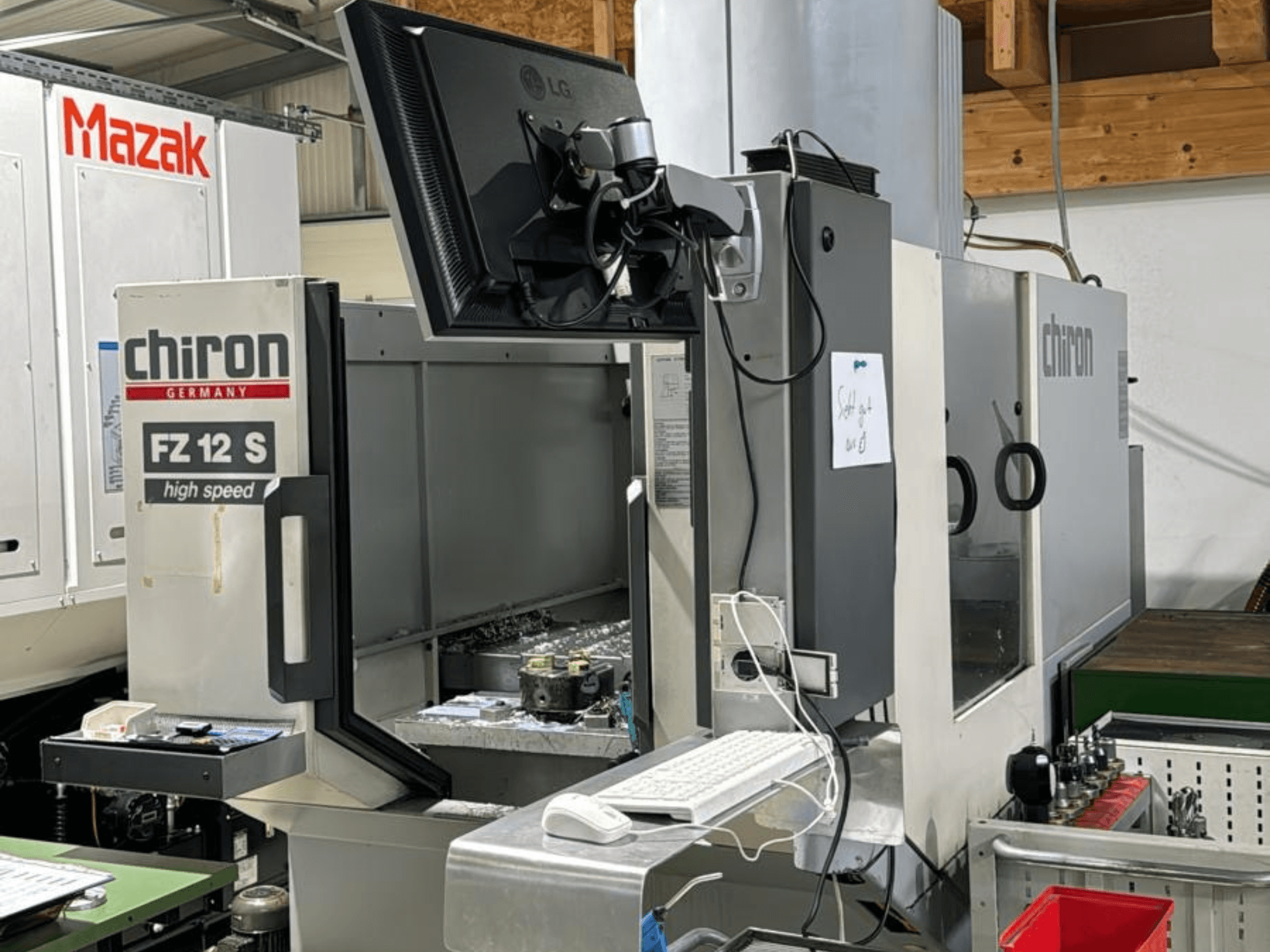 Вертикальный вид на высокоскоростной обрабатывающий центр CHIRON FZ 12 S с экраном управления и остатками от процесса обработки.