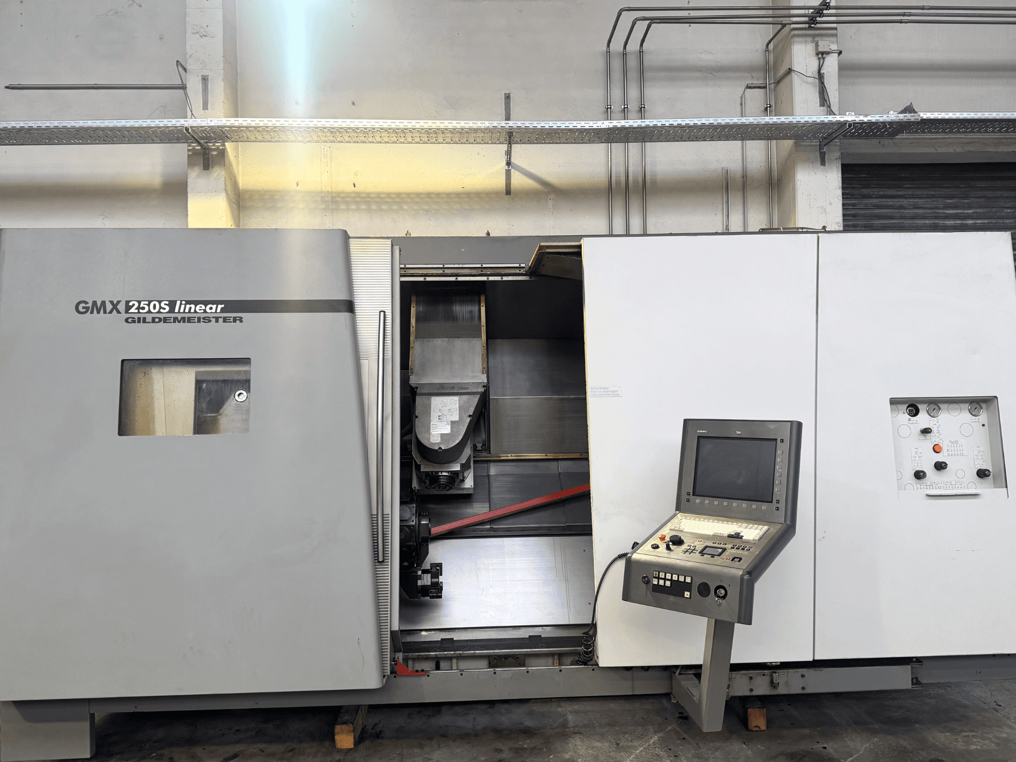 Линейный станок с ЧПУ Gildemeister GMX 250S, вид спереди, демонстрирует панель управления и открытую рабочую зону.