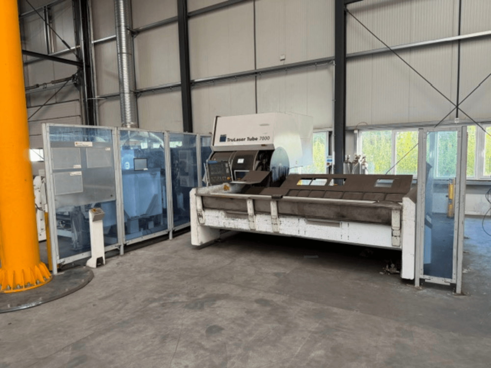 TruLaser Tube 7000 от TRUMPF — вид спереди на станок для резки труб в хорошо освещённом промышленном помещении с видимыми элементами управления.