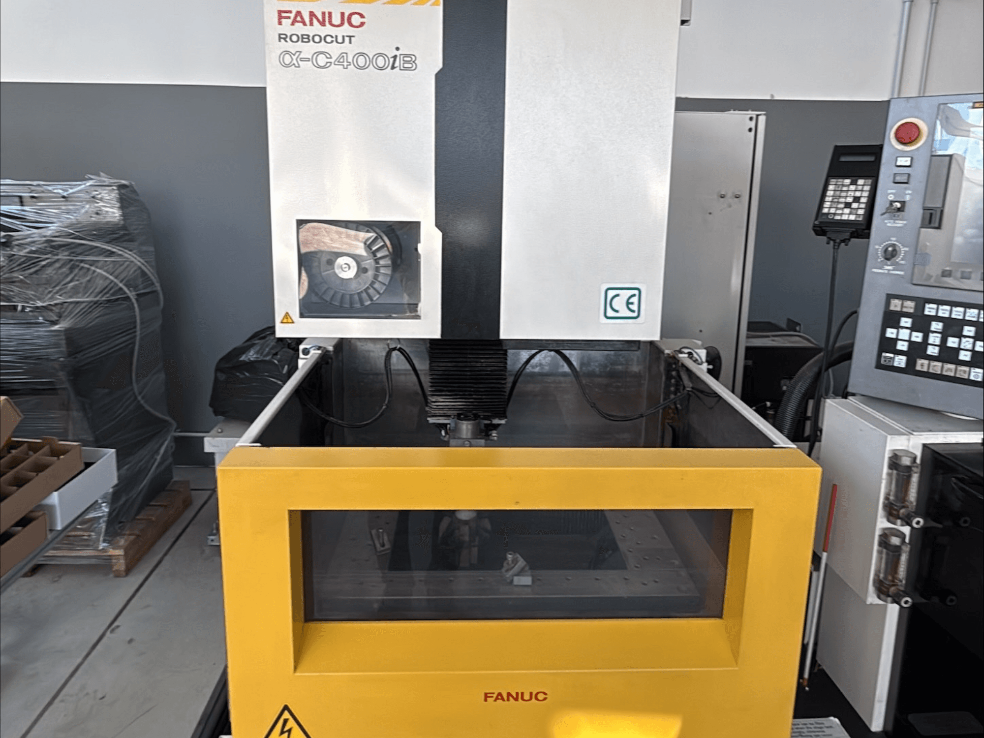 Проволочно-вырезной станок FANUC Robocut α-C400iB, вид спереди, с желтым баком и панелью управления.
