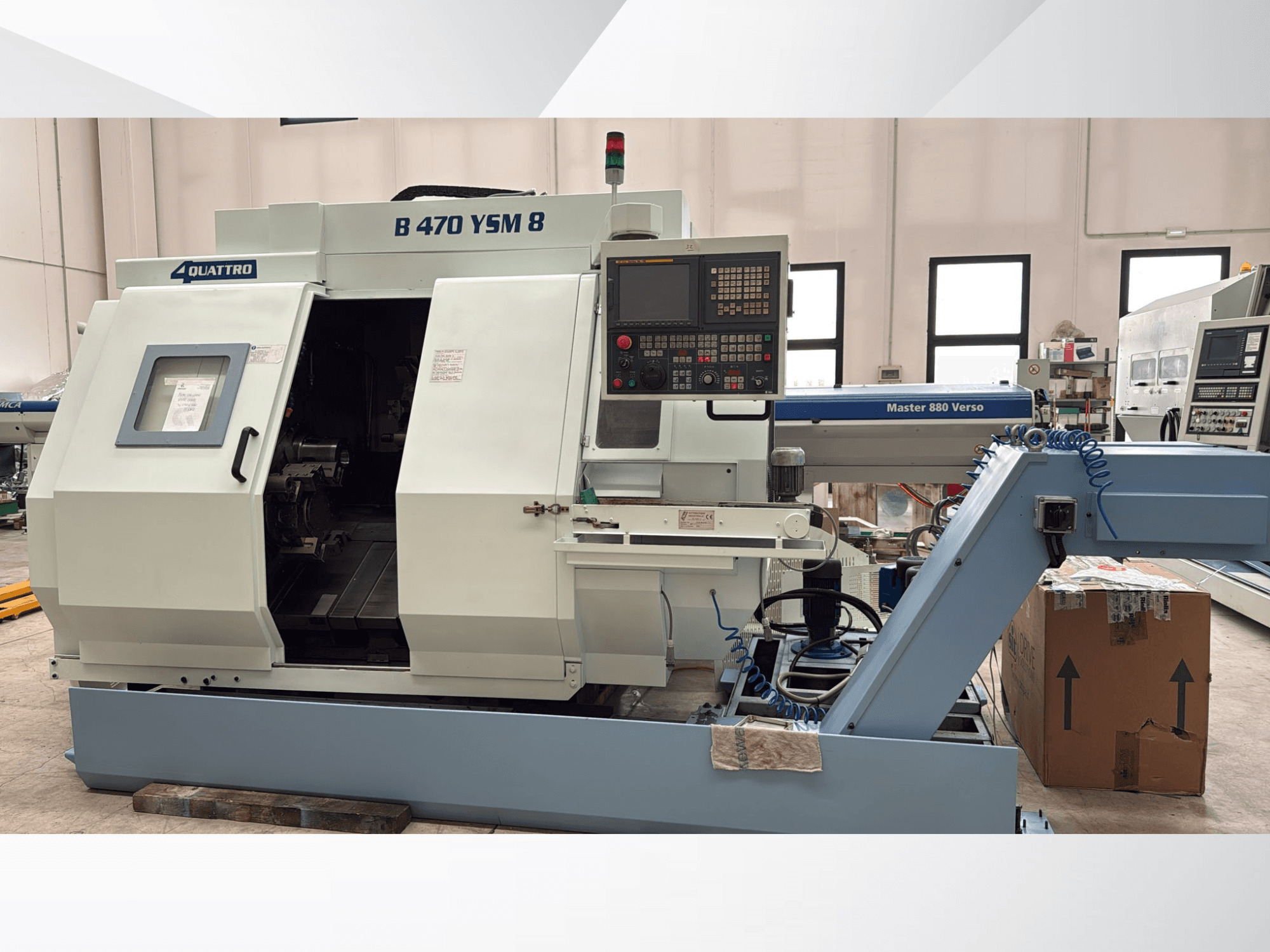 Токарно-фрезерный центр Biglia B470 YSM, вид спереди, на котором видны панель управления, открытый люк и рабочее место с инструментами внутри.