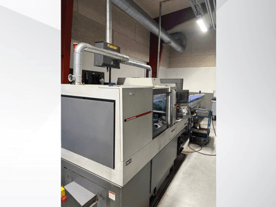 Промышленное оборудование от бренда MVC, вид сбоку с панелью управления и воздуховодами, установленное в заводских условиях.