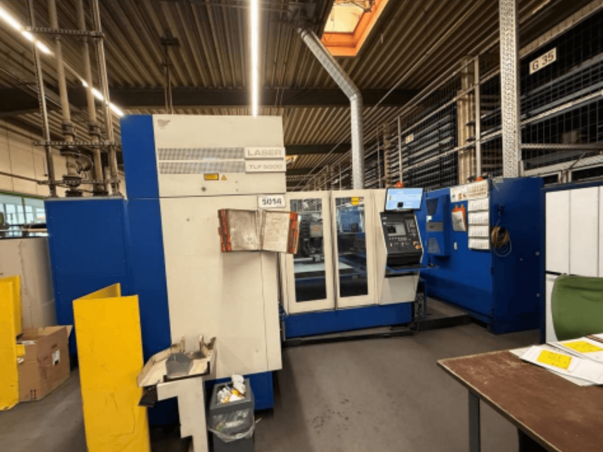 Вид спереди на станок лазерной резки CO2 TRUMPF Trumatic L 3050, демонстрирующий панель управления и рабочие функции в мастерской.