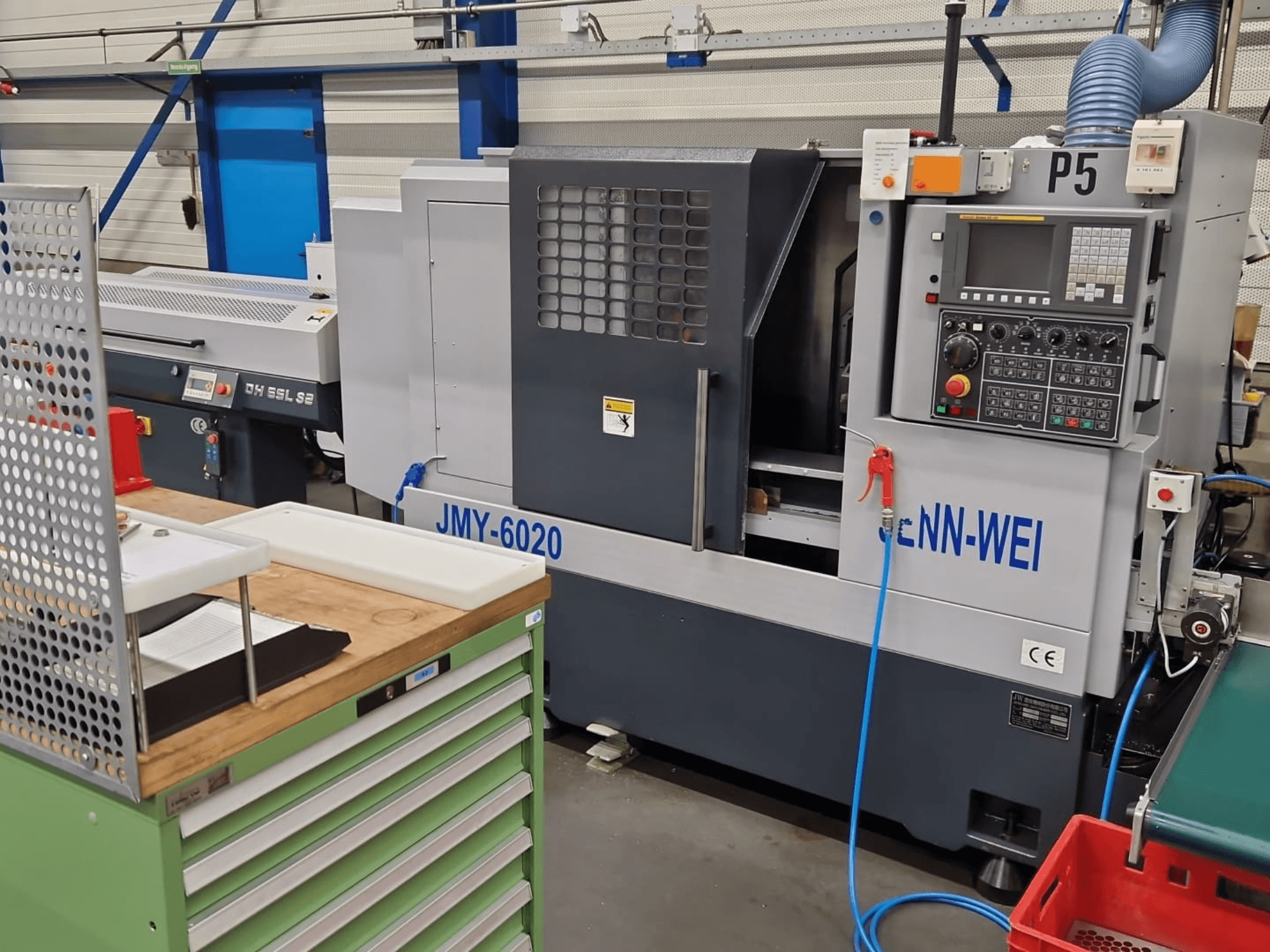 Токарный станок с ЧПУ, модель JMY-6020 производства cNN-WEI, вид спереди. Панель управления, аварийная остановка и линия подачи охлаждающей жидкости.