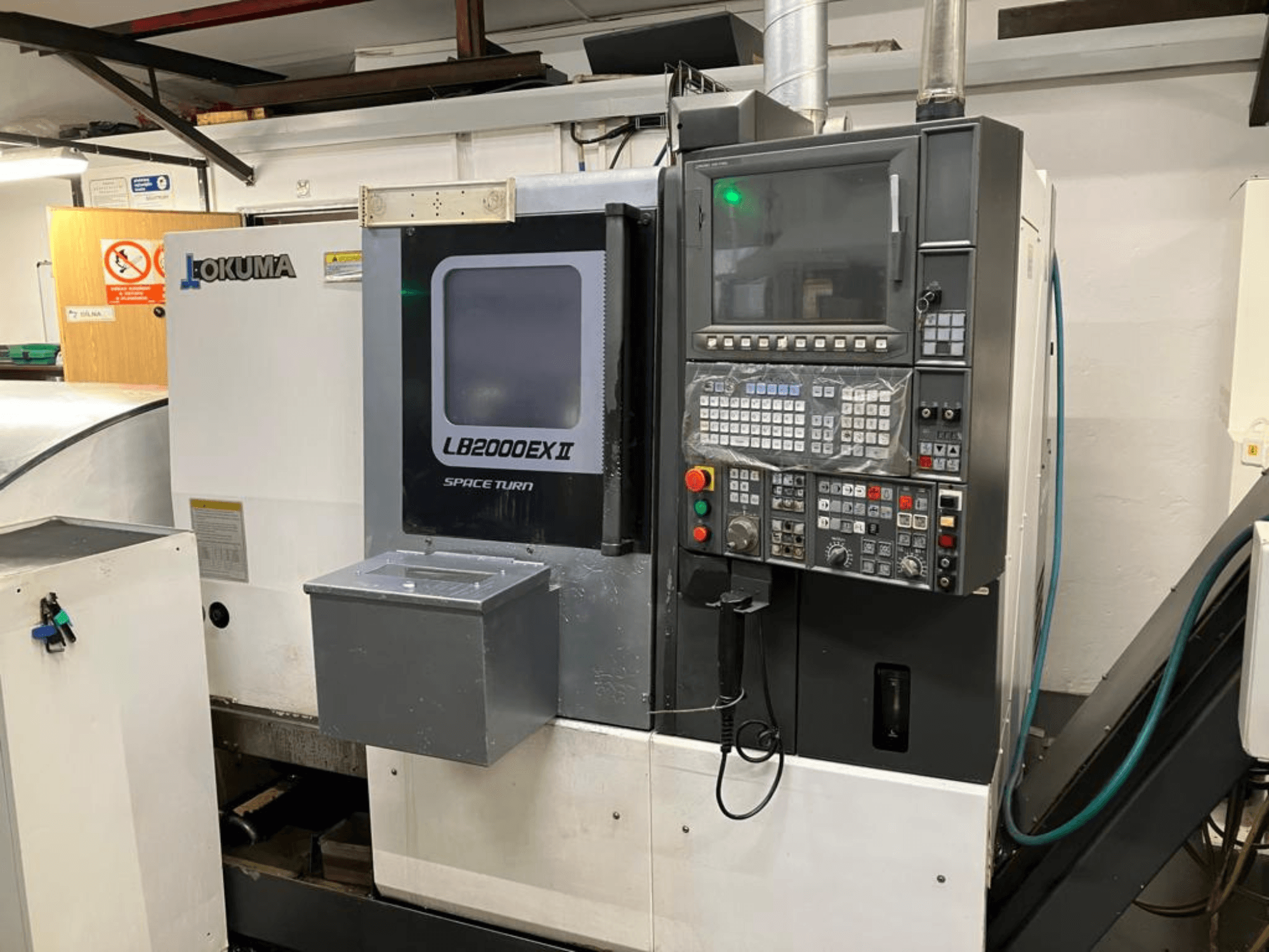Горизонтальный токарный станок Okuma LB2000EXII MC, вид спереди, демонстрирующий панель управления и эксплуатационные характеристики.