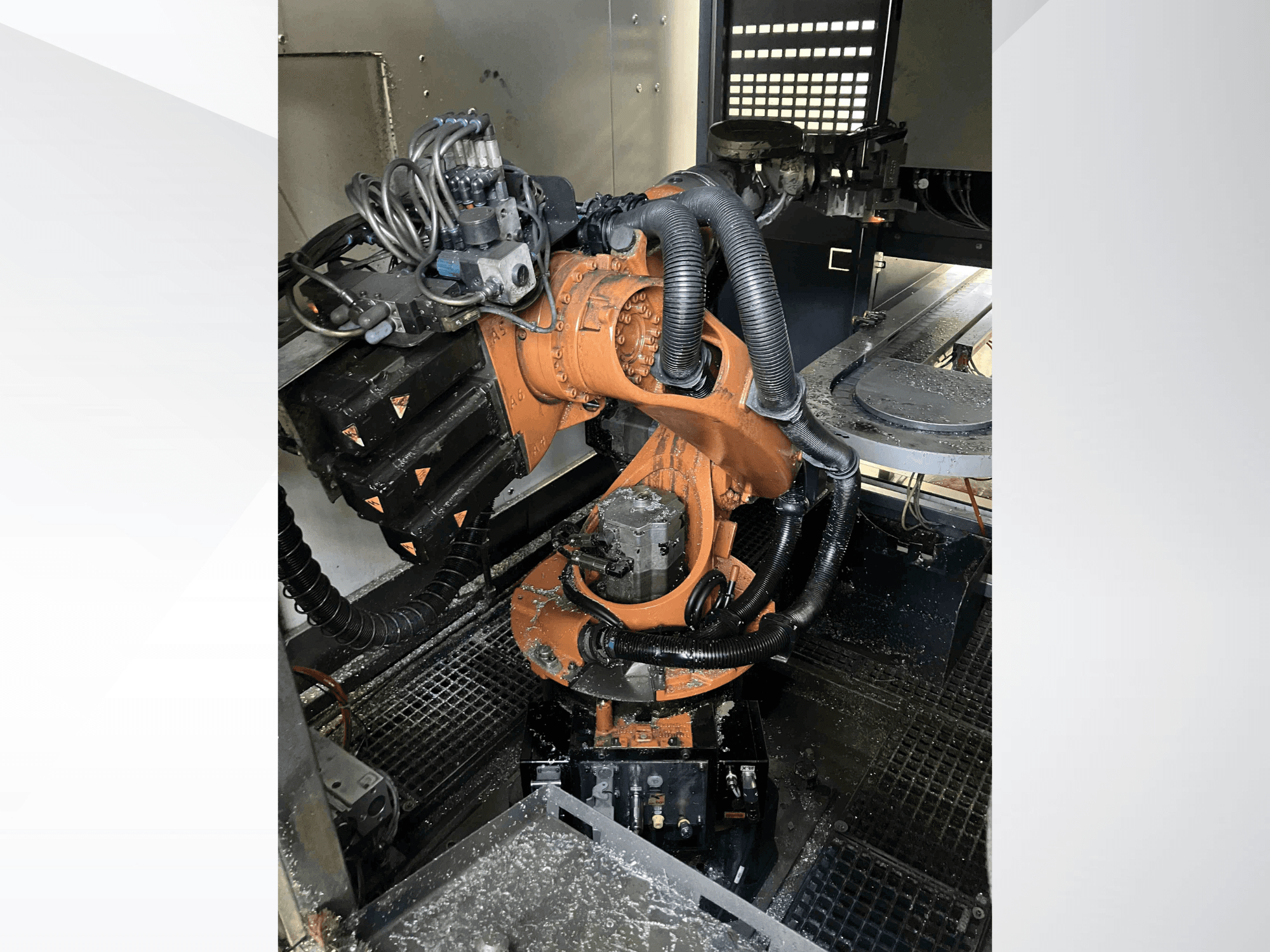 Роботизированная рука KUKA KR 16 в ракурсе сверху, демонстрирующая механические компоненты и проводку в условиях мастерской.