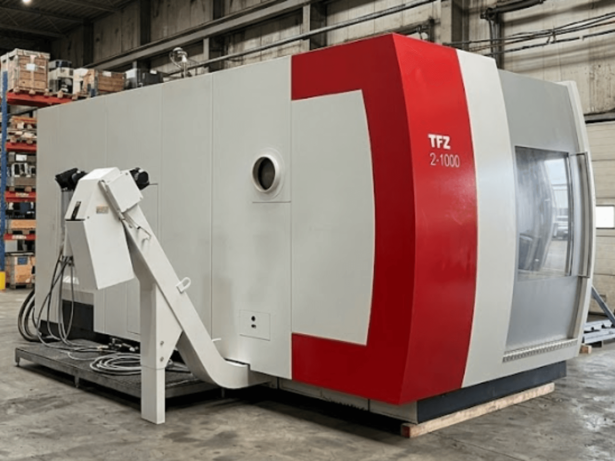 Универсальный обрабатывающий центр SAMAG TFZ 2L-1000, вид сбоку, демонстрирующий его красно-серый дизайн и установленный робот-манипулятор.