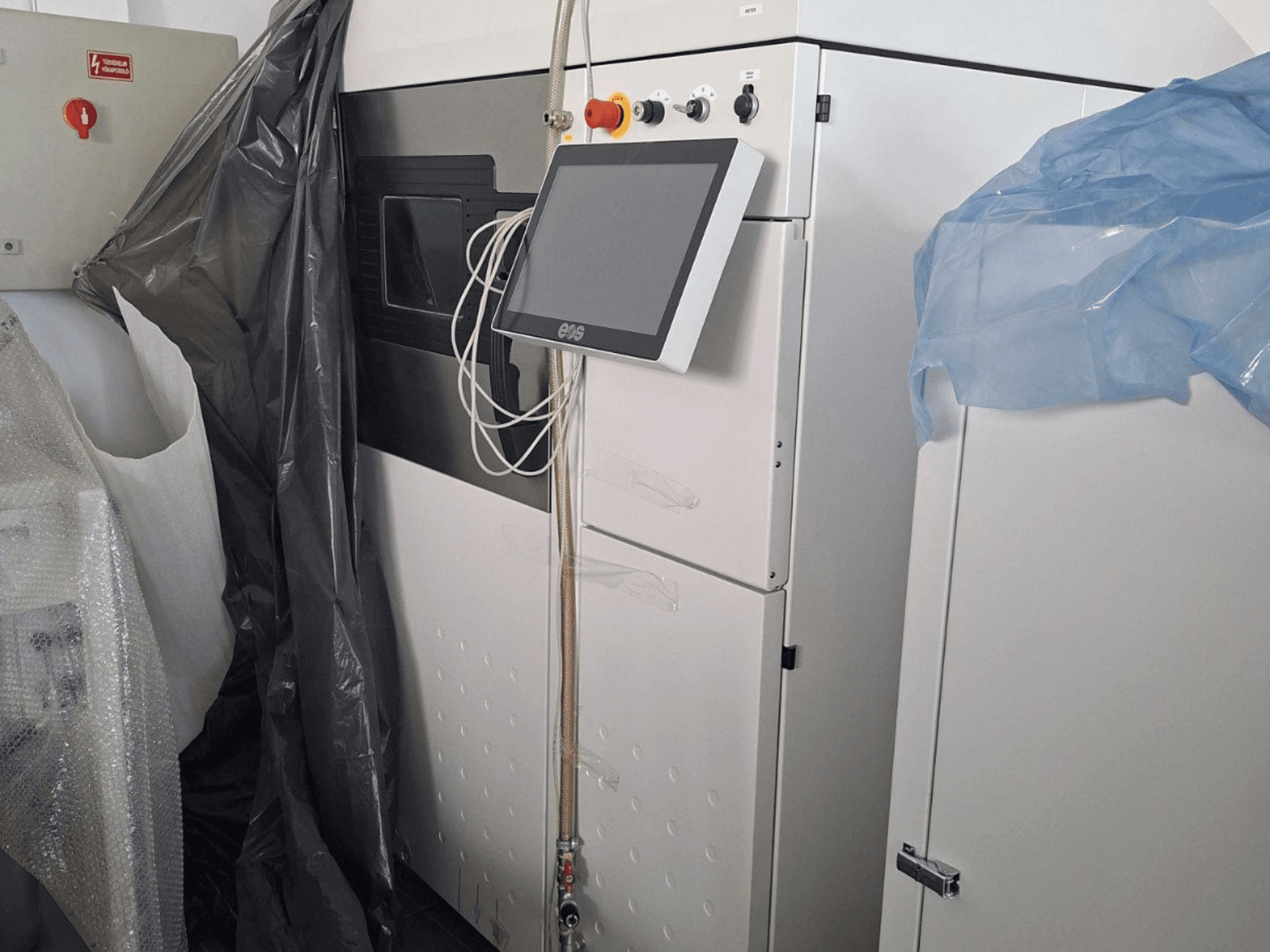 Вид спереди металлического 3D-принтера EOS M 290 с сенсорным экраном, панелью управления и защитными крышками.