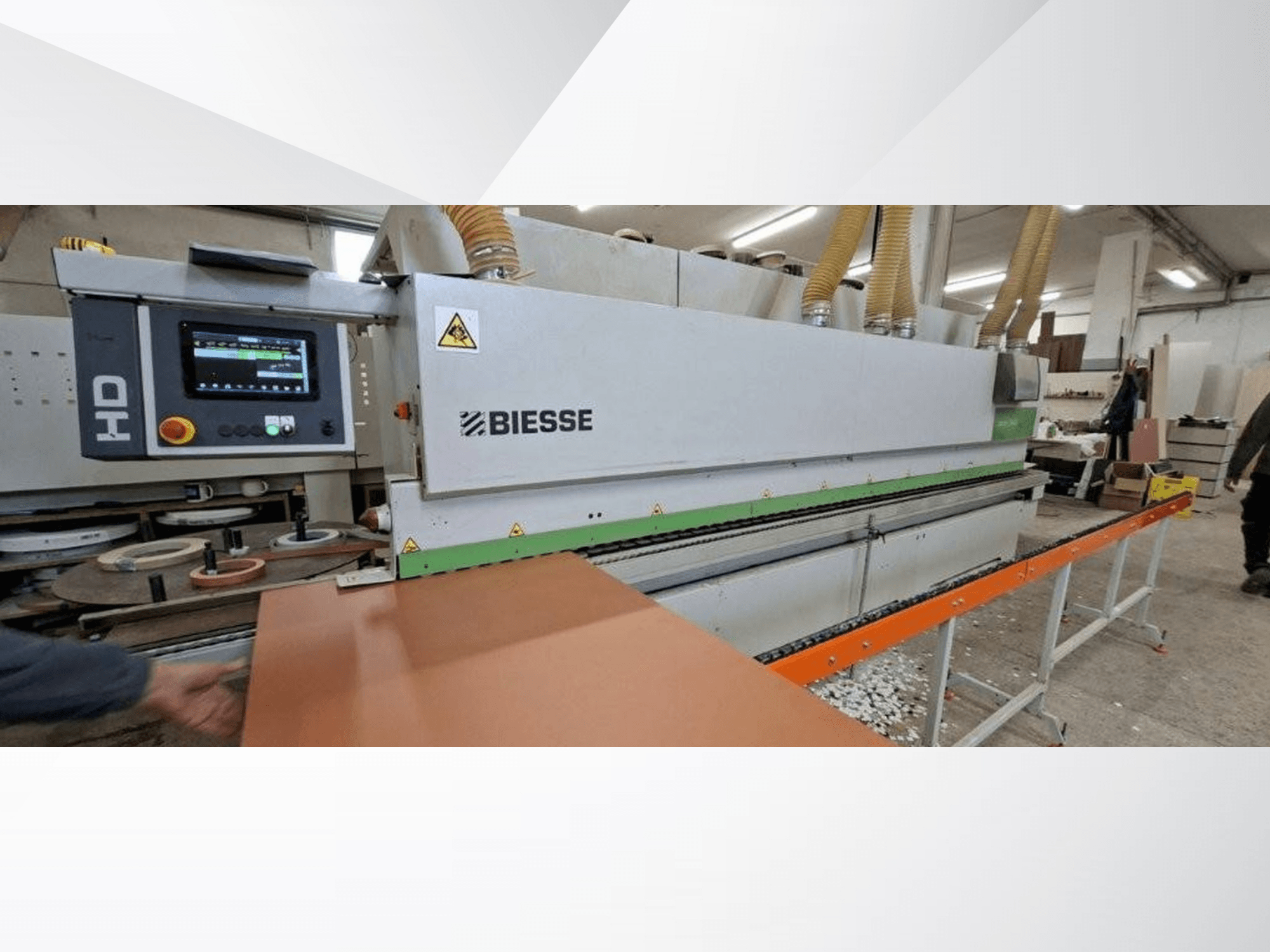 Кромкооблицовочная машина BIESSE JADE 340 в цехе, вид спереди с цифровой панелью управления и оранжевым подающим столом.