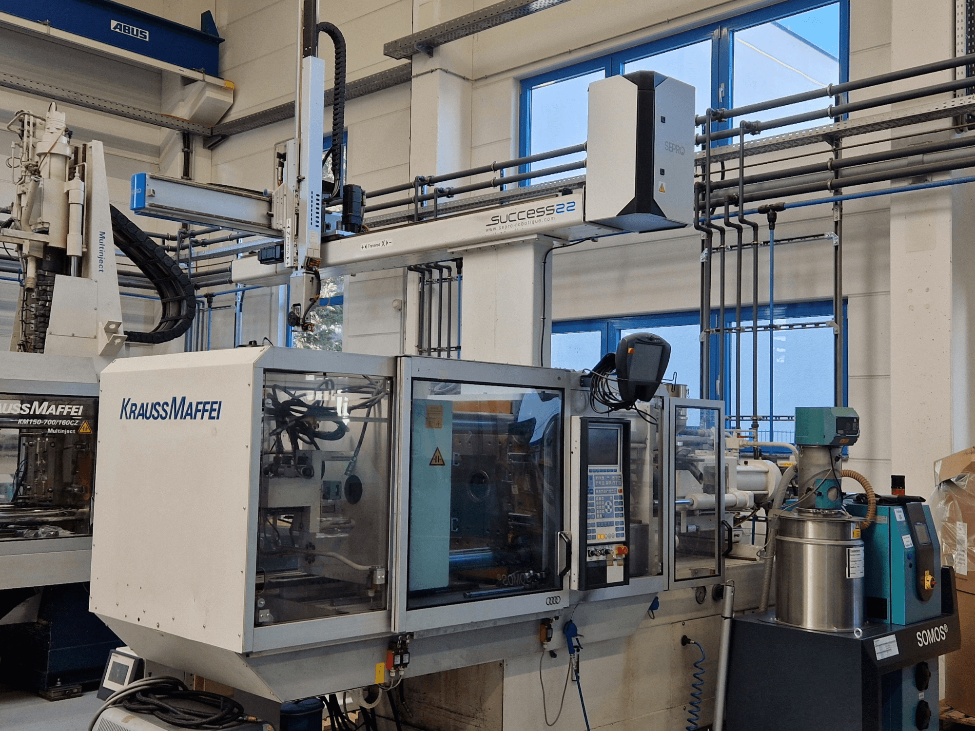 Термопластавтомат KraussMaffei Success 22 с панелью управления, вид спереди в заводских условиях.