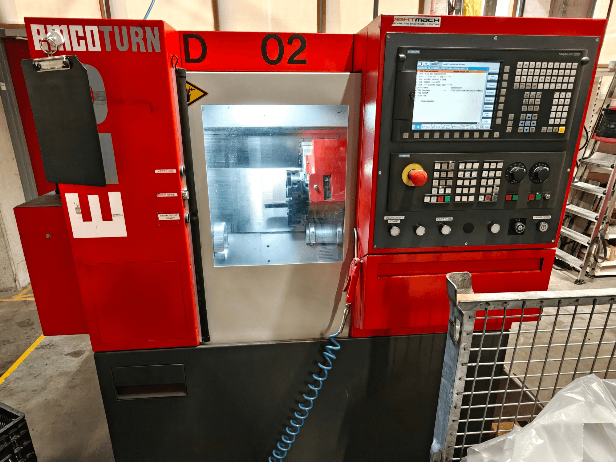 Вид спереди горизонтального токарного станка EMCO TURN E25 с панелью управления, дисплеем и зоной обработки.