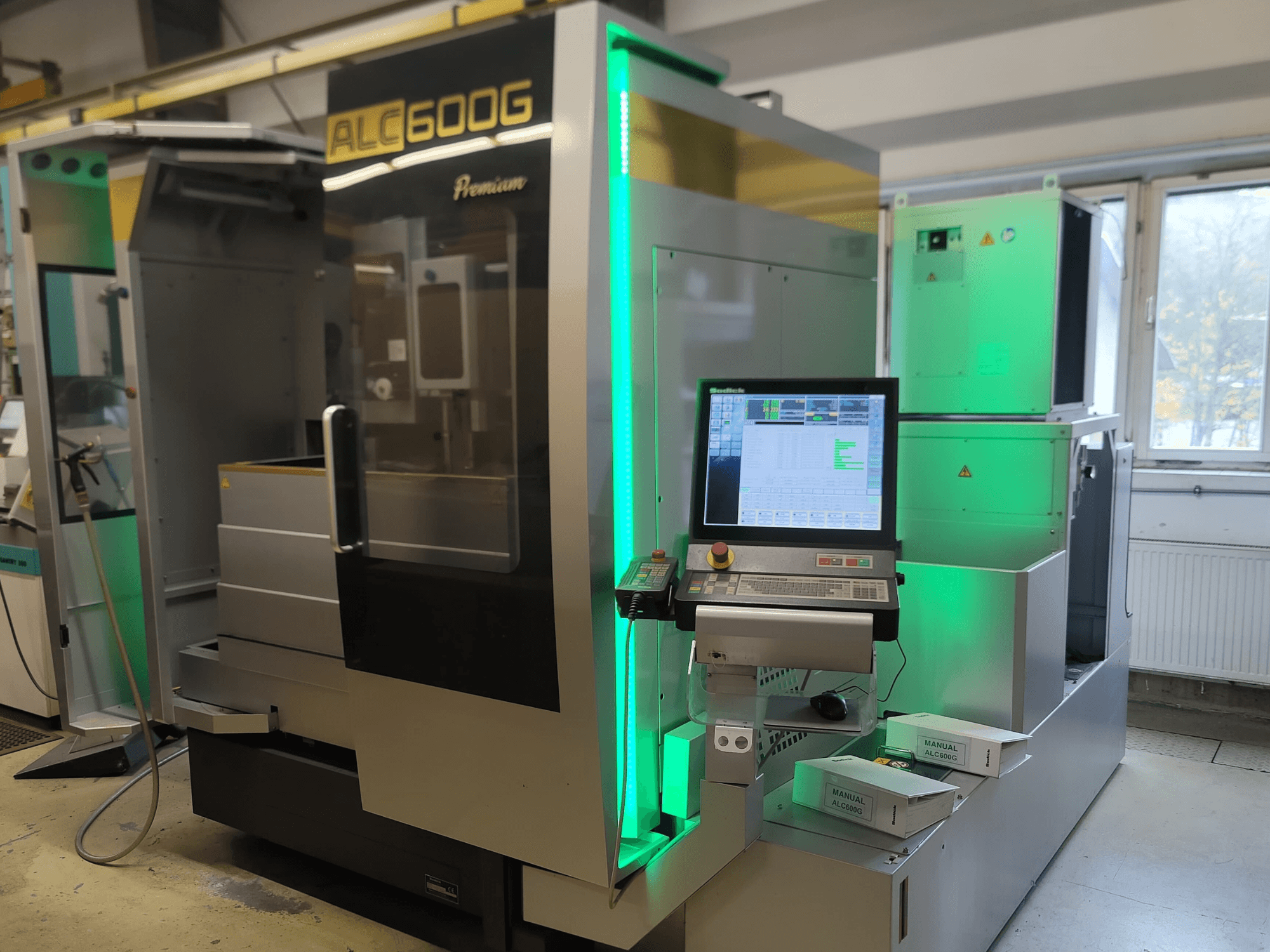 Проволочно-вырезной станок Sodick ALC600G Premium, вид спереди, демонстрирует панель управления и подсвеченные внешние детали.