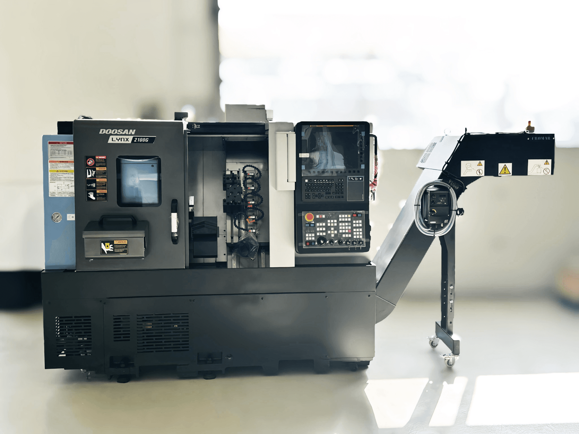Токарный станок DOOSAN LYNX 2100GA швейцарского типа на виде сбоку с панелью управления и держателем инструмента.