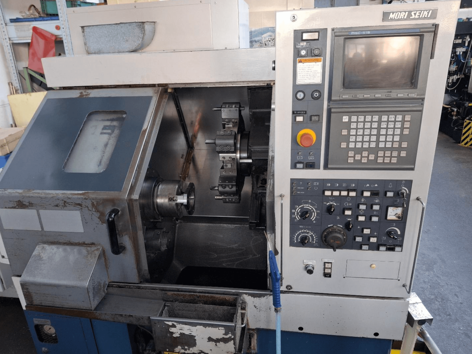 Горизонтальный токарный станок MORI SEIKI CL 15, вид спереди, демонстрирующий панель управления и зону обработки.