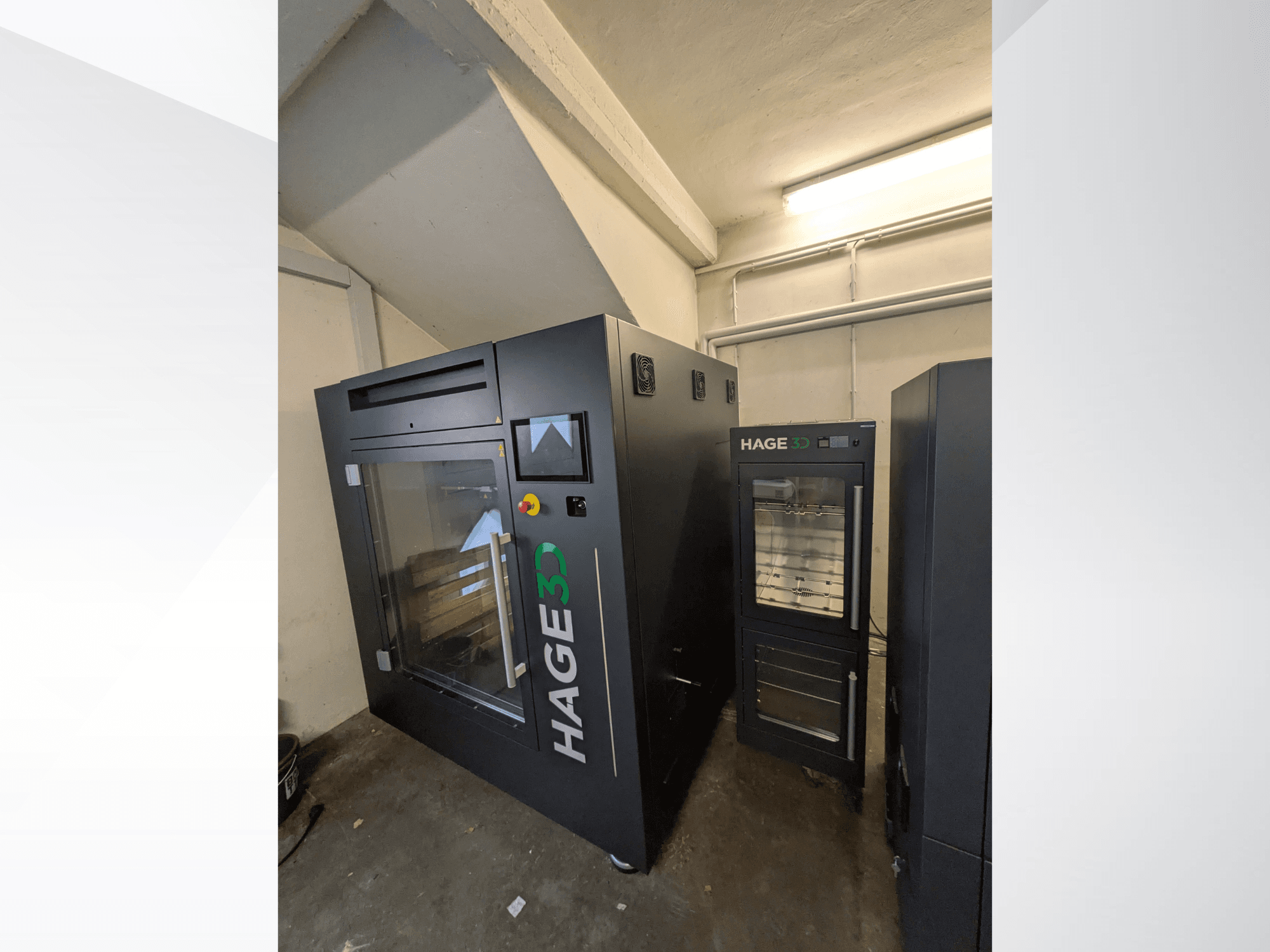 3D-принтер HAGE 3D Precision One для печати из пластика, вид сбоку: с прозрачной дверцей и панелью управления, рядом с ним — место для хранения.