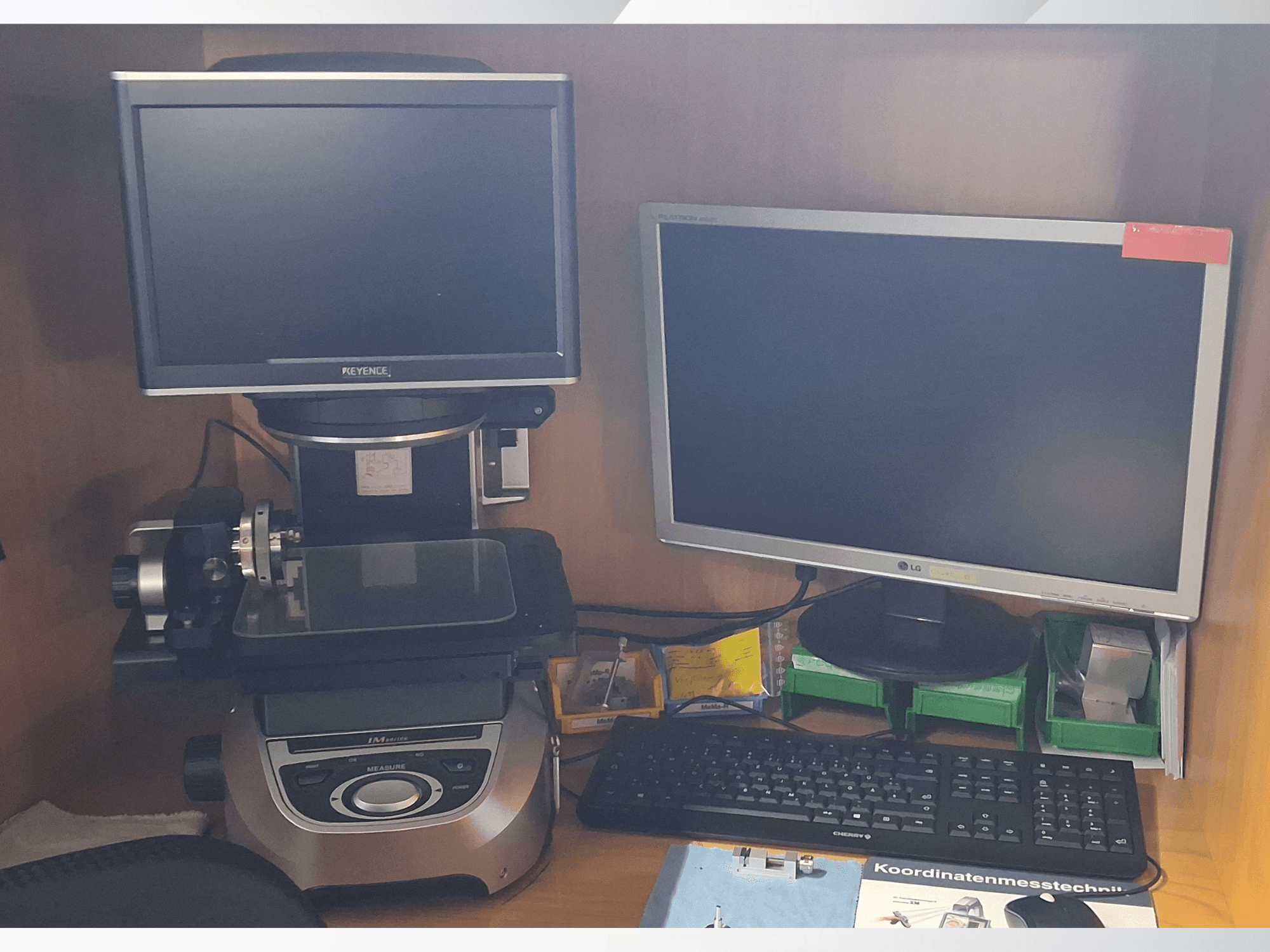 Измерительная система Keyence с двумя мониторами (один LG, один Keyence) и клавиатурой, вид спереди.