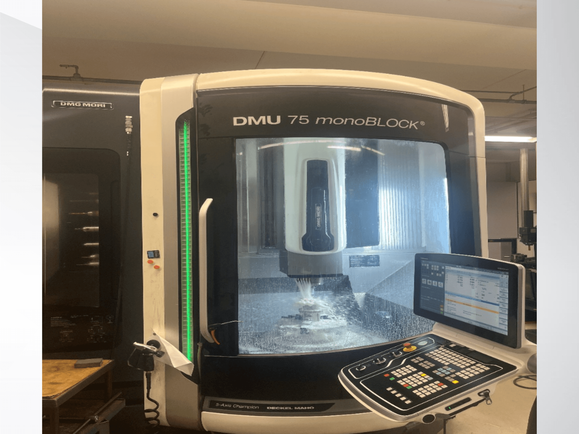 Универсальный обрабатывающий центр DMG MORI DMU 75 monoBLOCK в виде спереди, на котором видны панель управления и зона фрезерования.