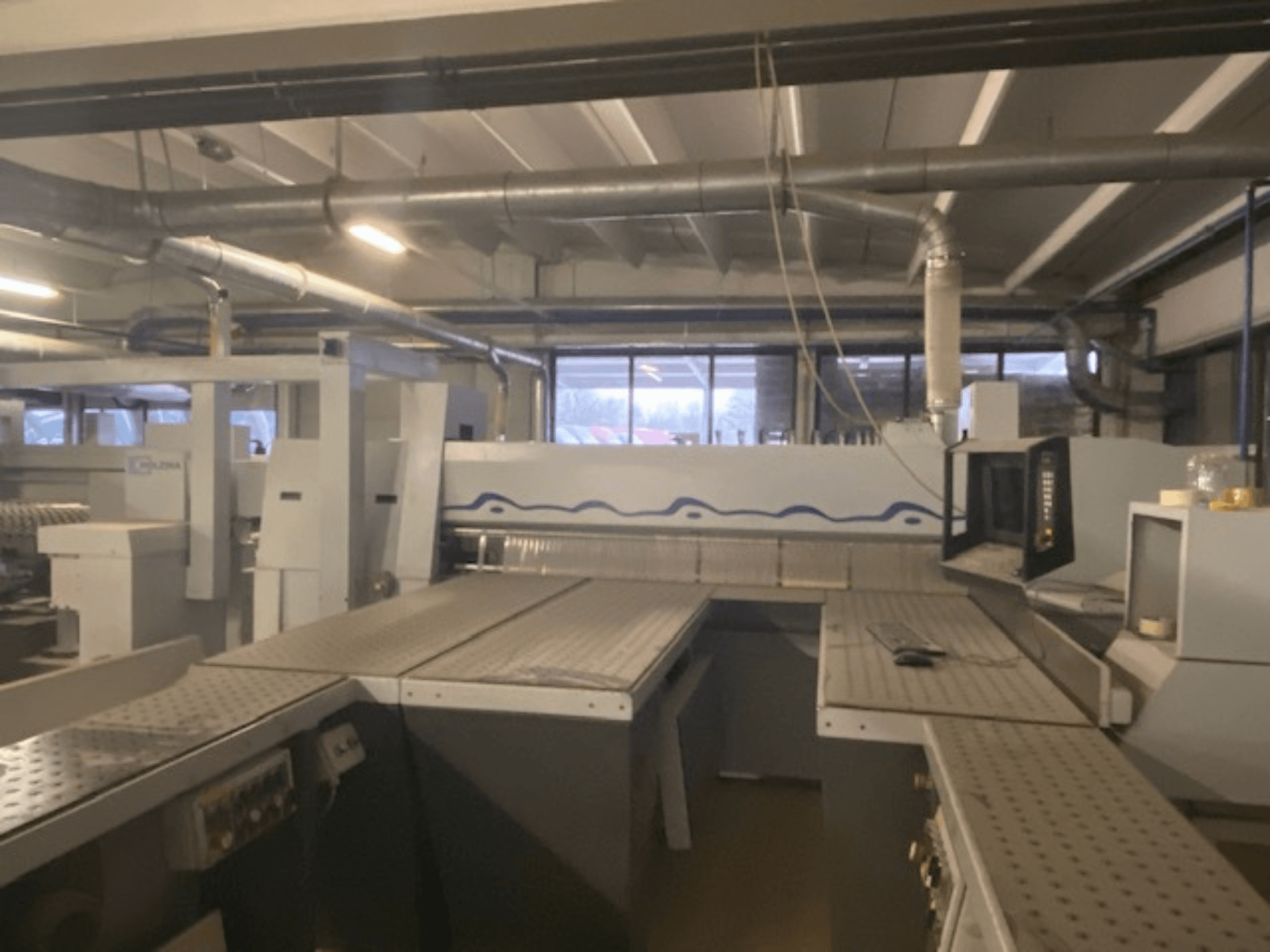 Промышленная рабочая зона с оборудованием и панелью управления, вид с возвышенного фронтального ракурса.