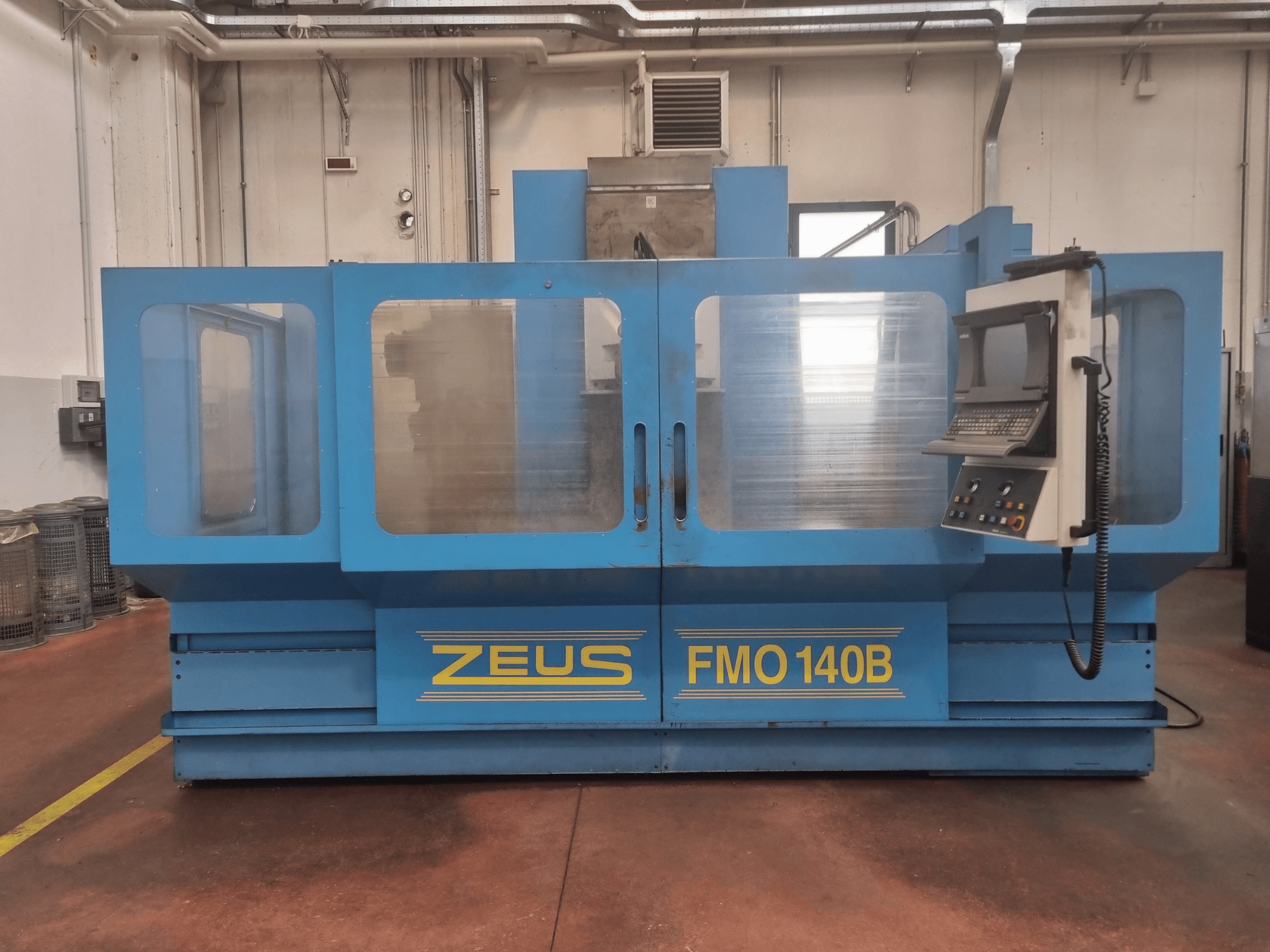 Машина Zeus FMO 140B синего цвета, вид спереди; панель управления и большие прозрачные панели для наглядности.
