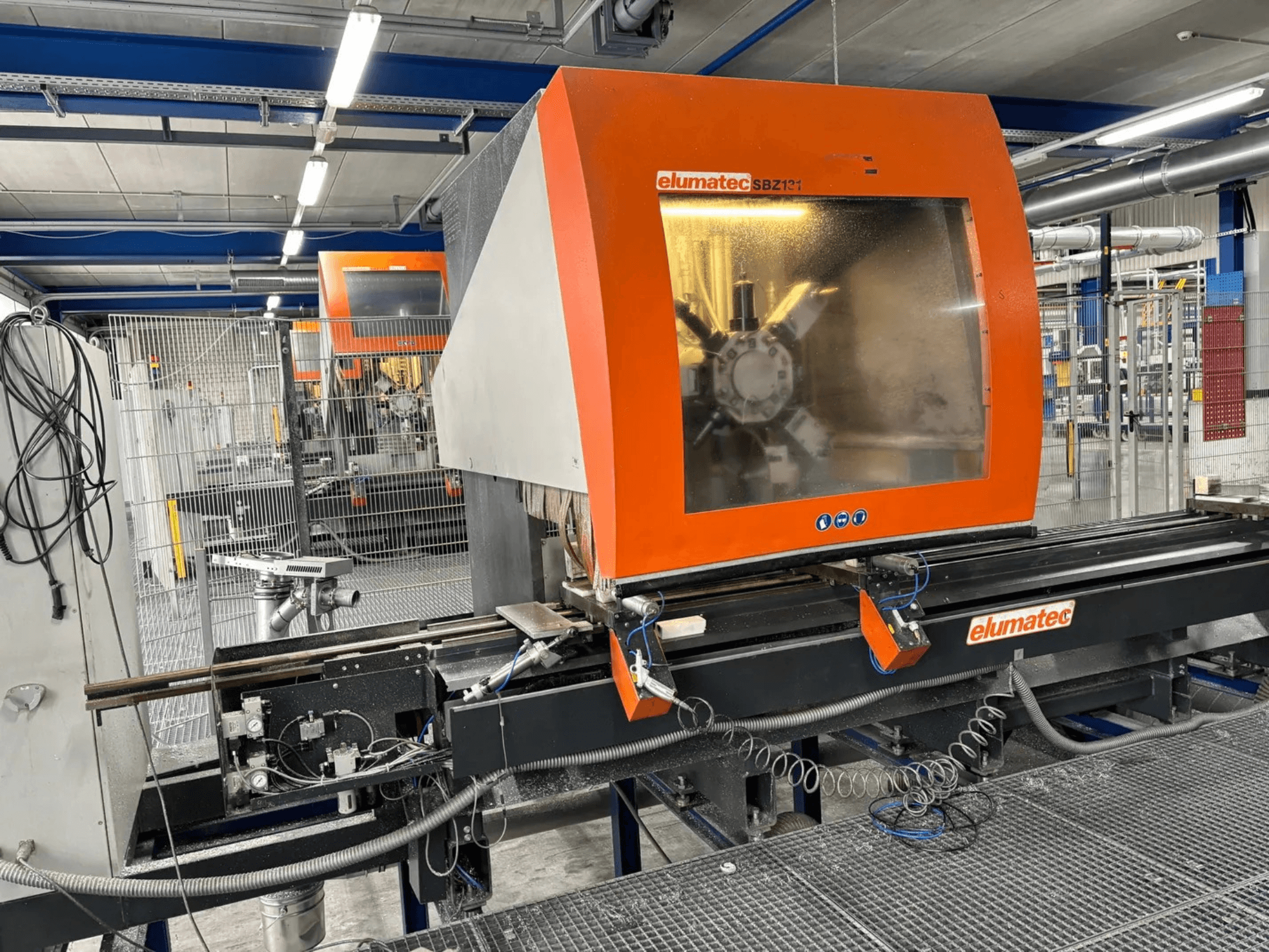 Вертикальный обрабатывающий центр Elumatec SBZ 131, вид спереди, демонстрирует панель управления, детали оборудования и окружающую рабочую обстановку.