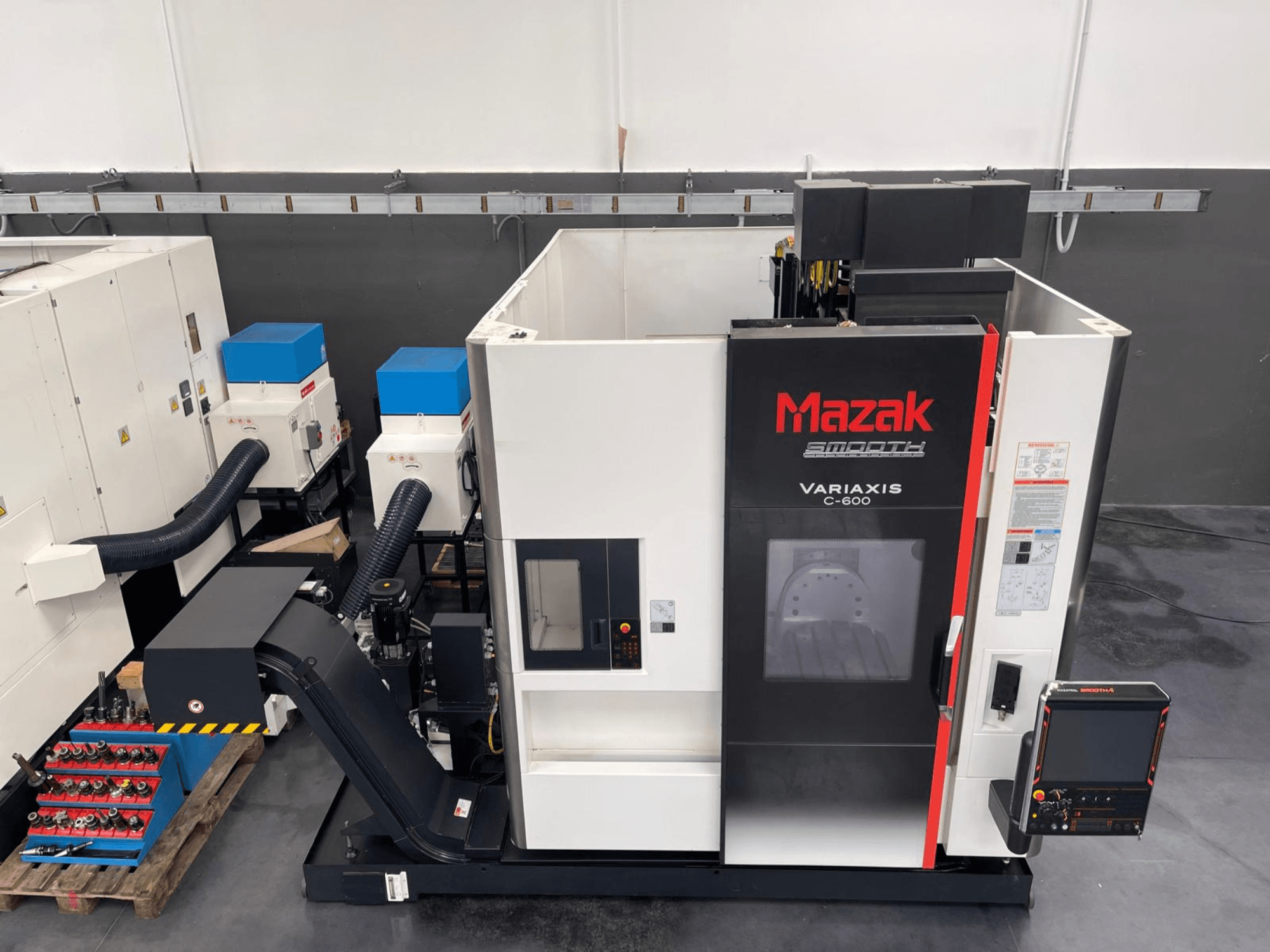 Вертикальный обрабатывающий центр Mazak VARIAXIS C 600, вид спереди, демонстрирующий панель управления и хранилище инструментов.