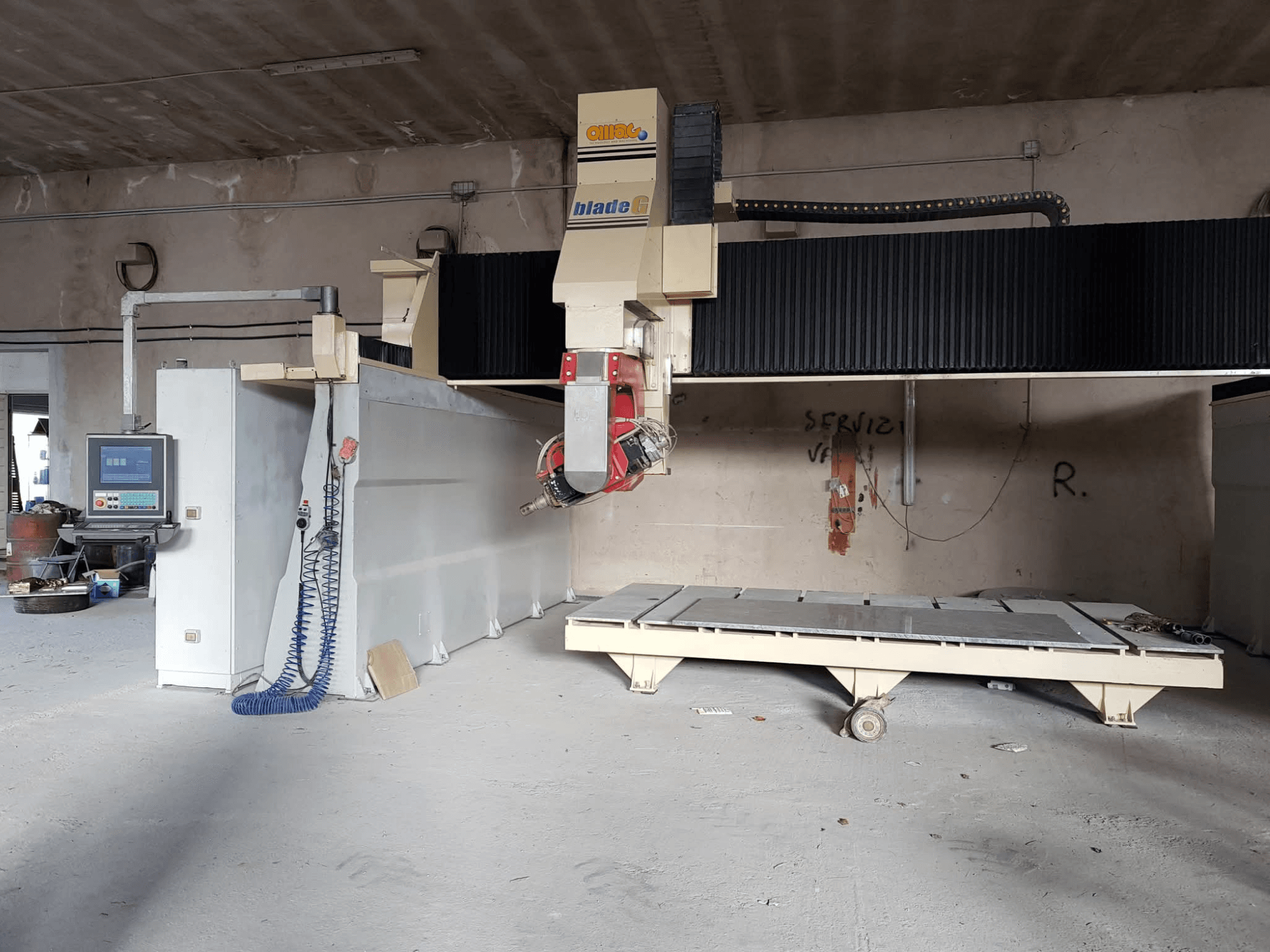 Портальный фрезерный станок OMAG Blade G в мастерской, вид спереди, видна панель управления и большая фрезерная станина.
