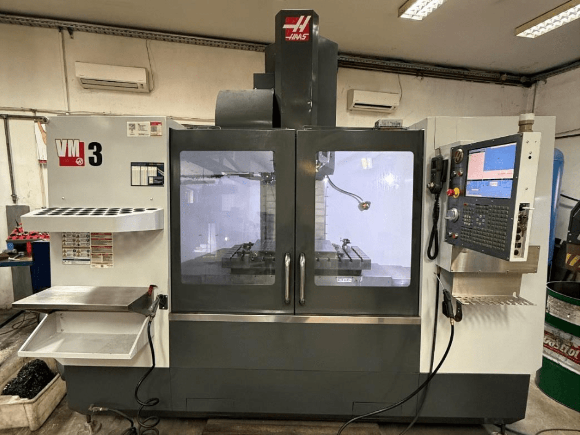Вертикальный обрабатывающий центр Haas VM-3, вид спереди: на фотографии видна большая панель управления и рабочая зона с инструментами.
