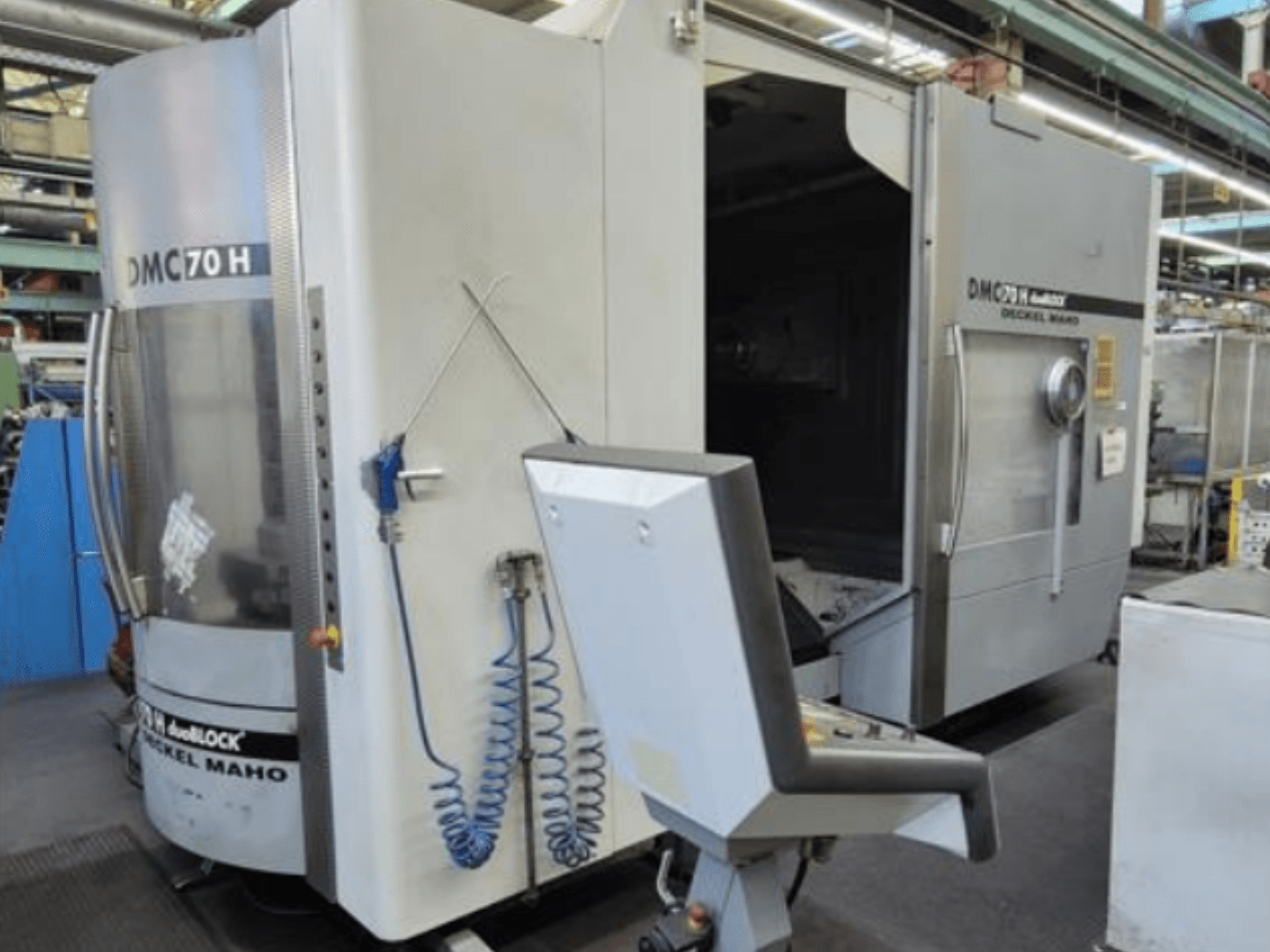Вид спереди на дуоблочный горизонтальный обрабатывающий центр DECKEL MAHO DMC 70 H с панелью управления и видимой зоной обработки.