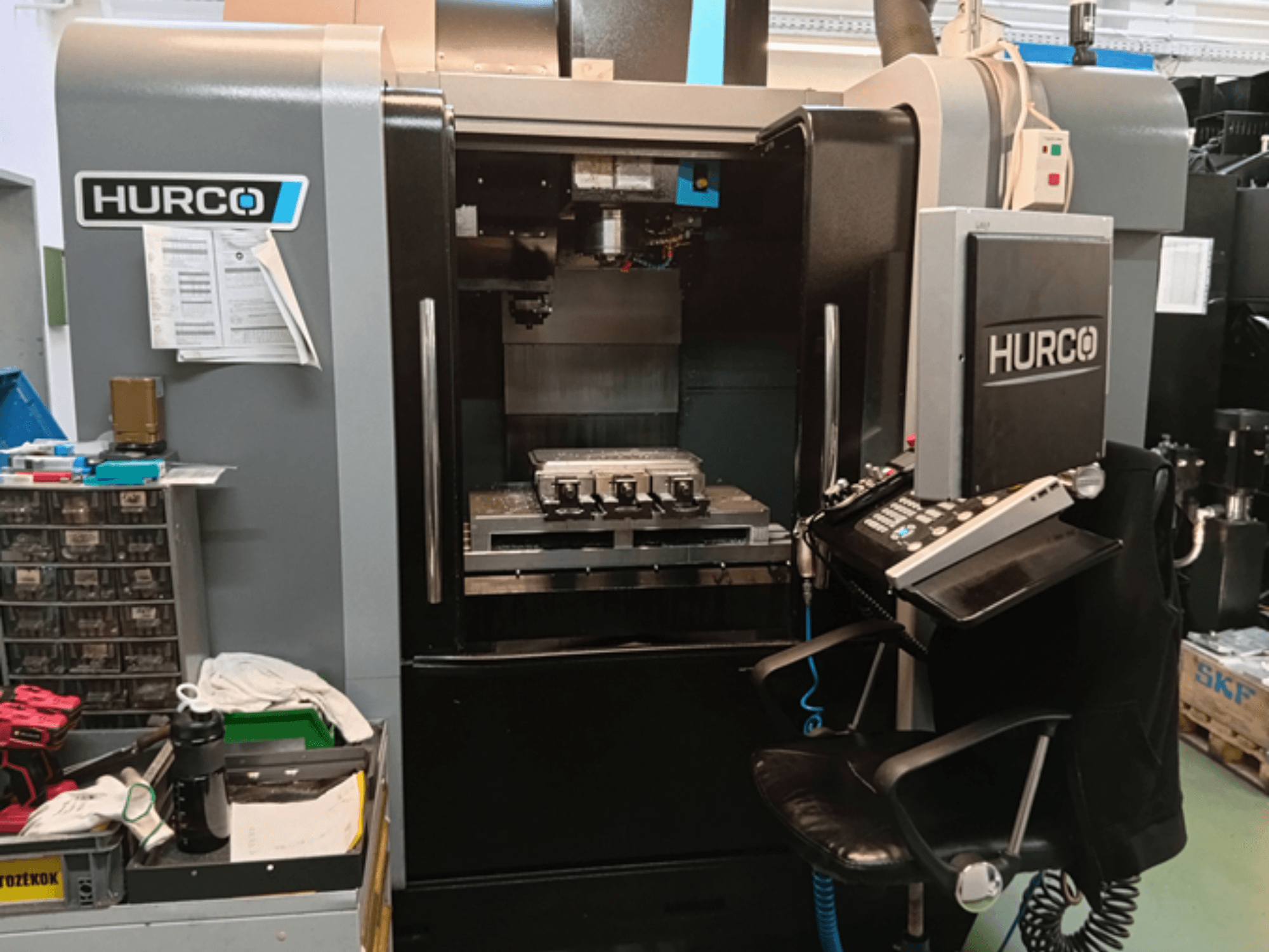 Вертикальный обрабатывающий центр Hurco VMX 30i с видом спереди, с панелью управления, рабочим столом и операционной настройкой.