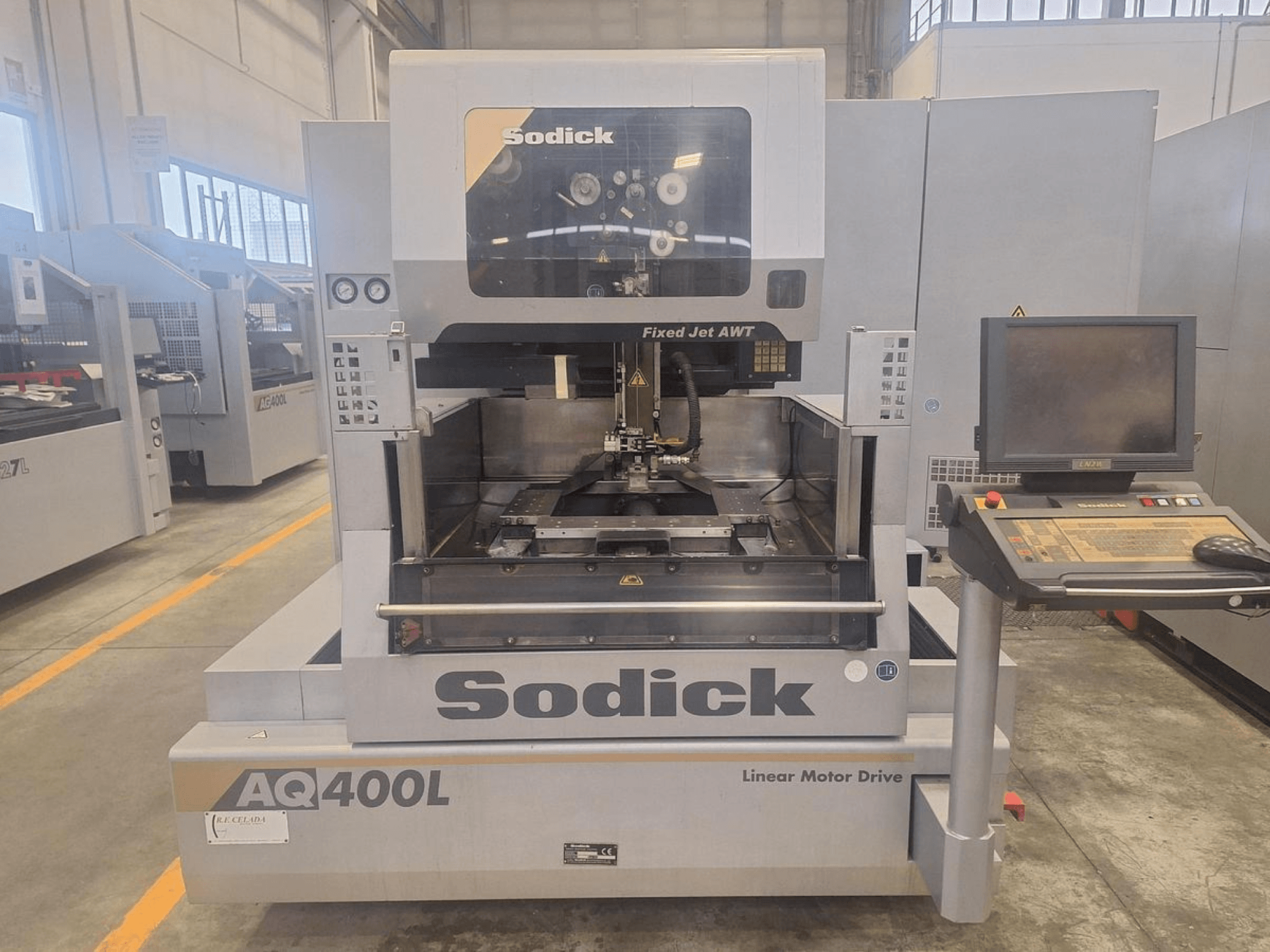 Станок с линейным приводом Sodick AQ400L, показанный спереди, с панелью управления и внутренней рабочей зоной.