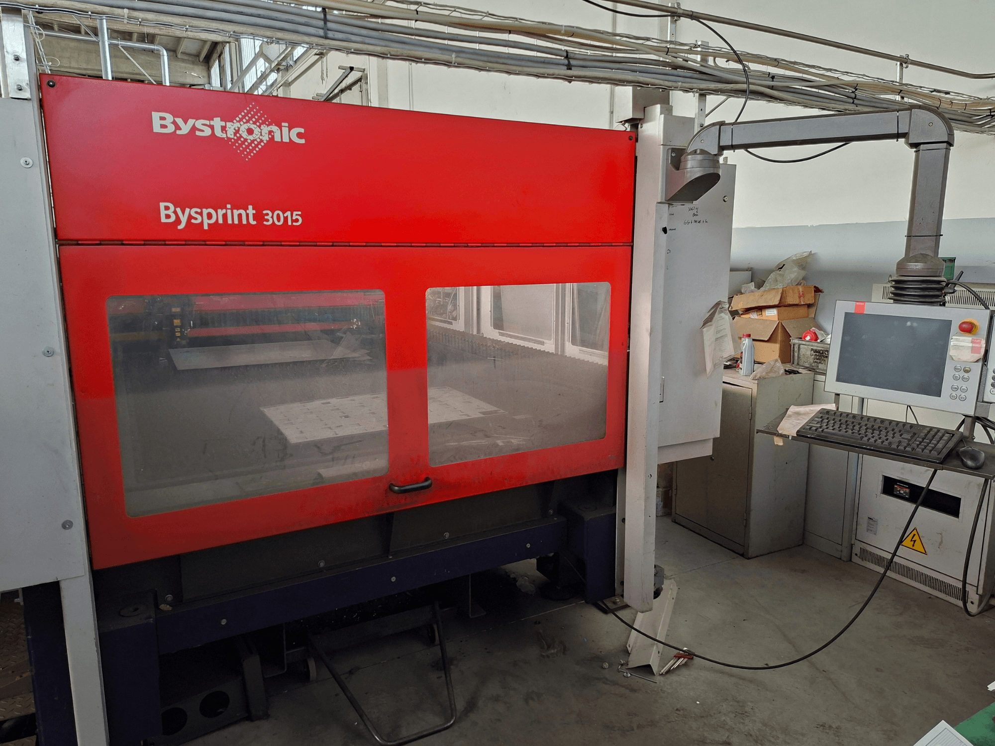 Лазерный резак Bystronic Bysprint 3015 с CO₂-лазером, вид спереди с панелью управления и зоной лазерной резки.