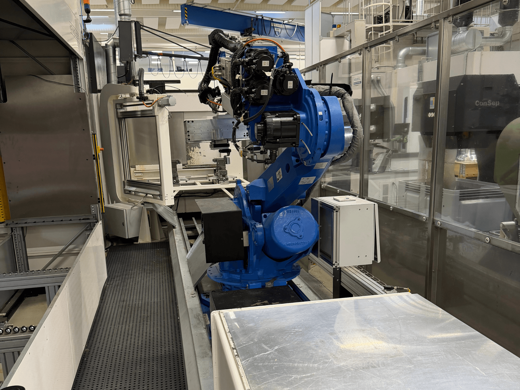 Роботизированный манипулятор Yaskawa Motoman ES165D на рельсе, вид сбоку, демонстрирующий установку автоматики в промышленной среде.