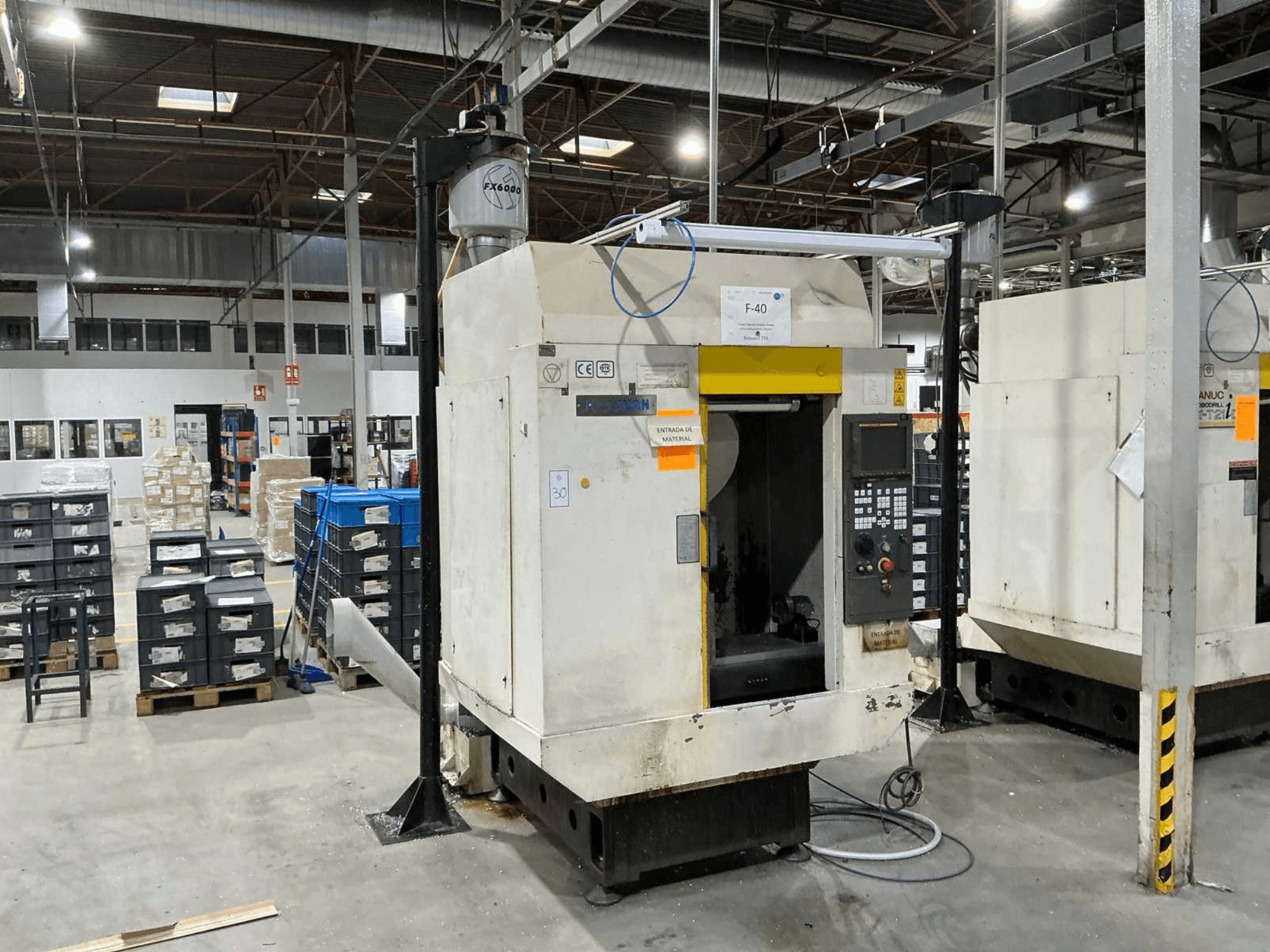 FANUC ROBODRILL α-T21iD, вид спереди вертикального обрабатывающего центра в промышленной обстановке, видны детали панели управления.