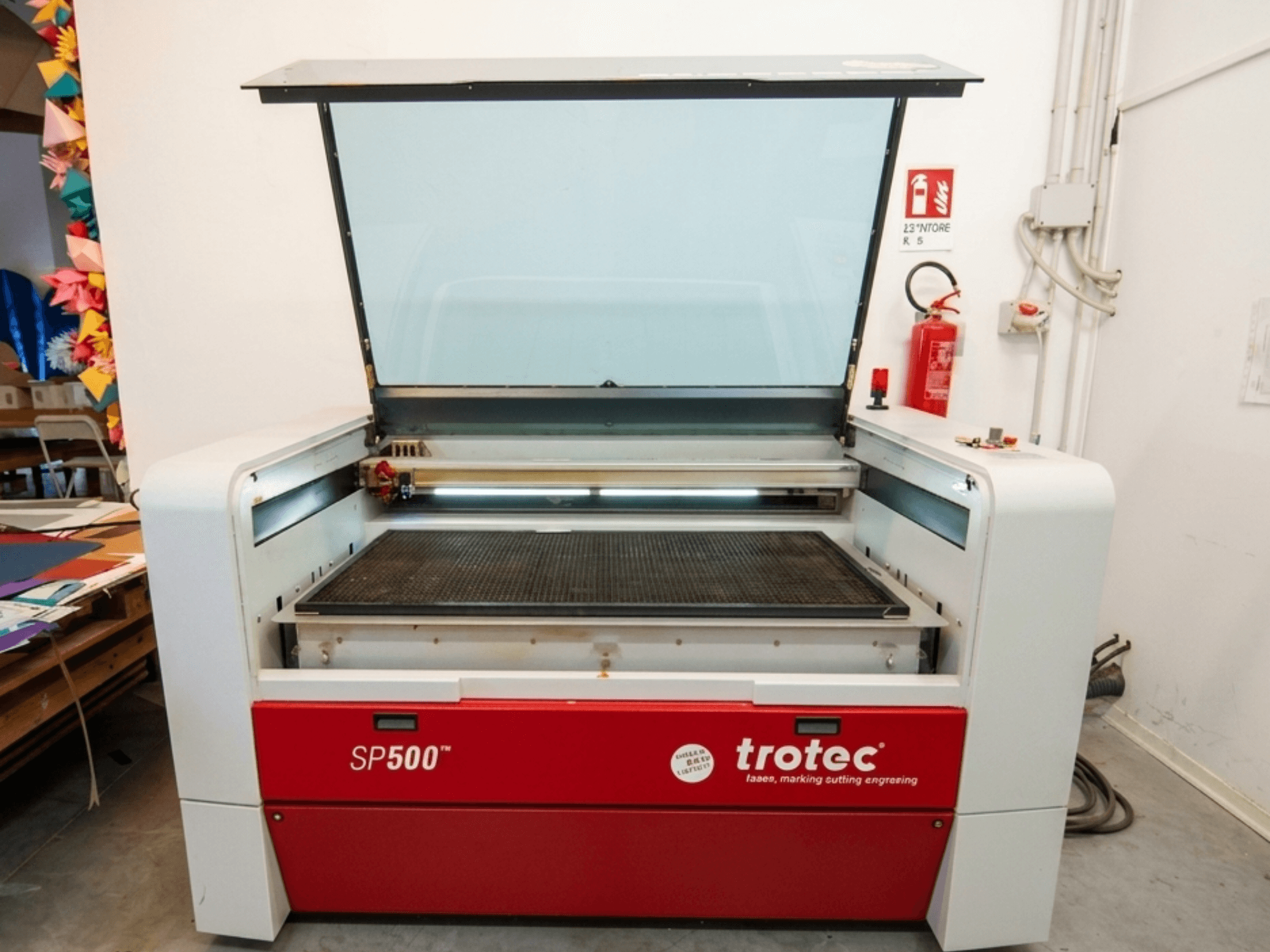Лазерный гравировальный станок Trotec SP500 C200 с видом спереди, с открытой крышкой, показывающей рабочую зону и элементы управления.