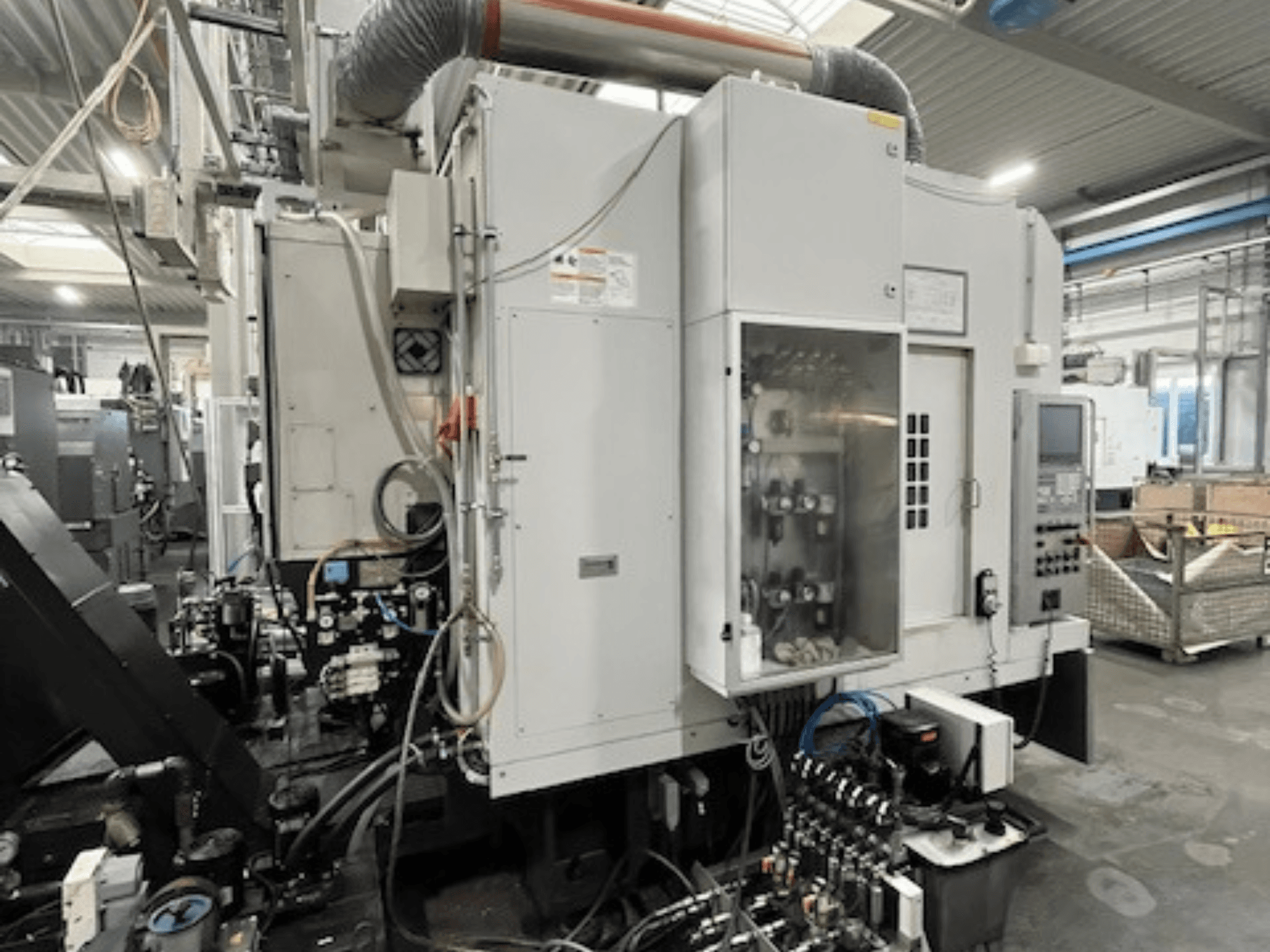 Вид сбоку на промышленную машину с панелью управления и гидравлическими компонентами, с указанием марки и модели.