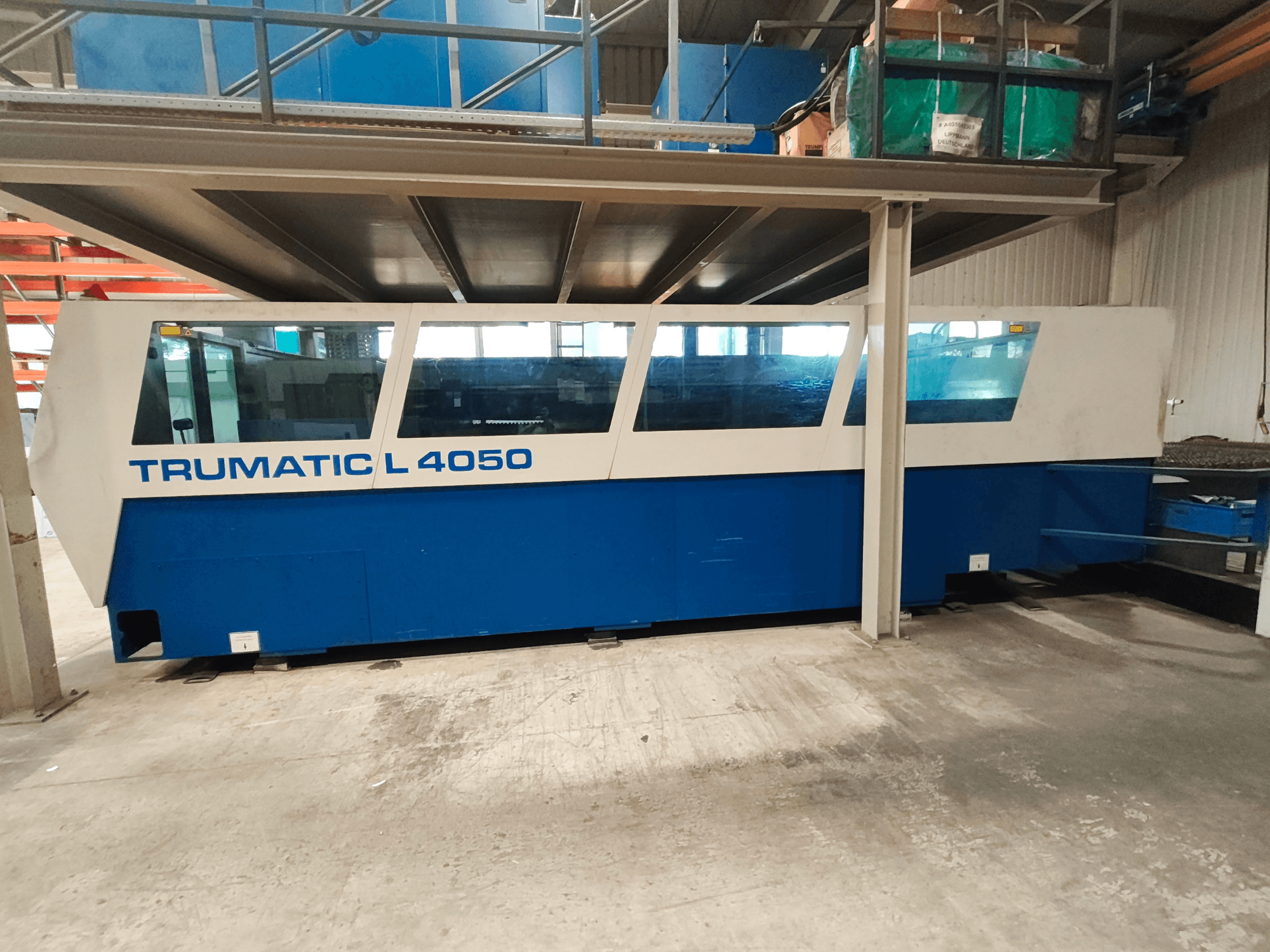 Станок для лазерной резки CO2 TRUMPF TruLaser 450 в боковом виде, выполненный в сине-белой цветовой гамме, с видимой панелью управления и рабочей зоной.
