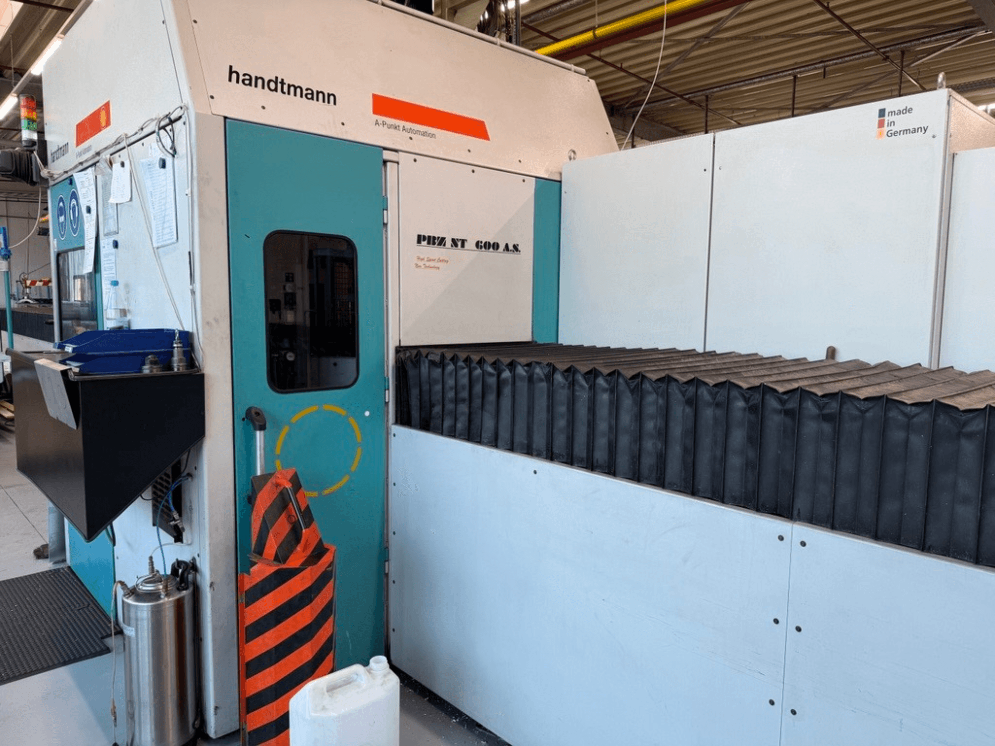 Вид спереди портального фрезерного станка Handtmann PBZ NT 600 AS с темной рабочей поверхностью и защитными ограждениями.