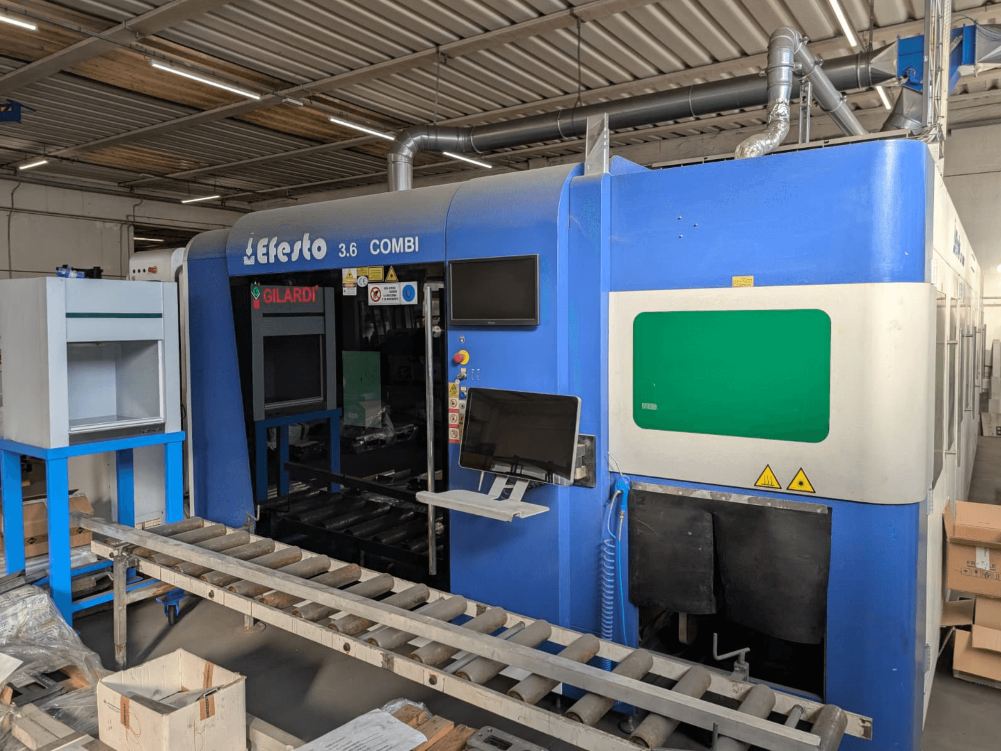 Станок для лазерной резки на волоконном лазере EFESTO 3.6 COMBI, вид сбоку, с панелью управления и индикаторами безопасности, с синим корпусом.