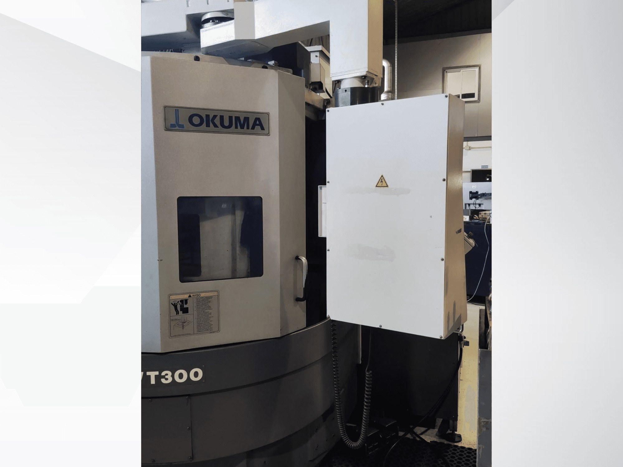Вертикальный токарный станок Okuma LVT300, вид спереди, демонстрирует панель управления и обозначенные функции безопасности.