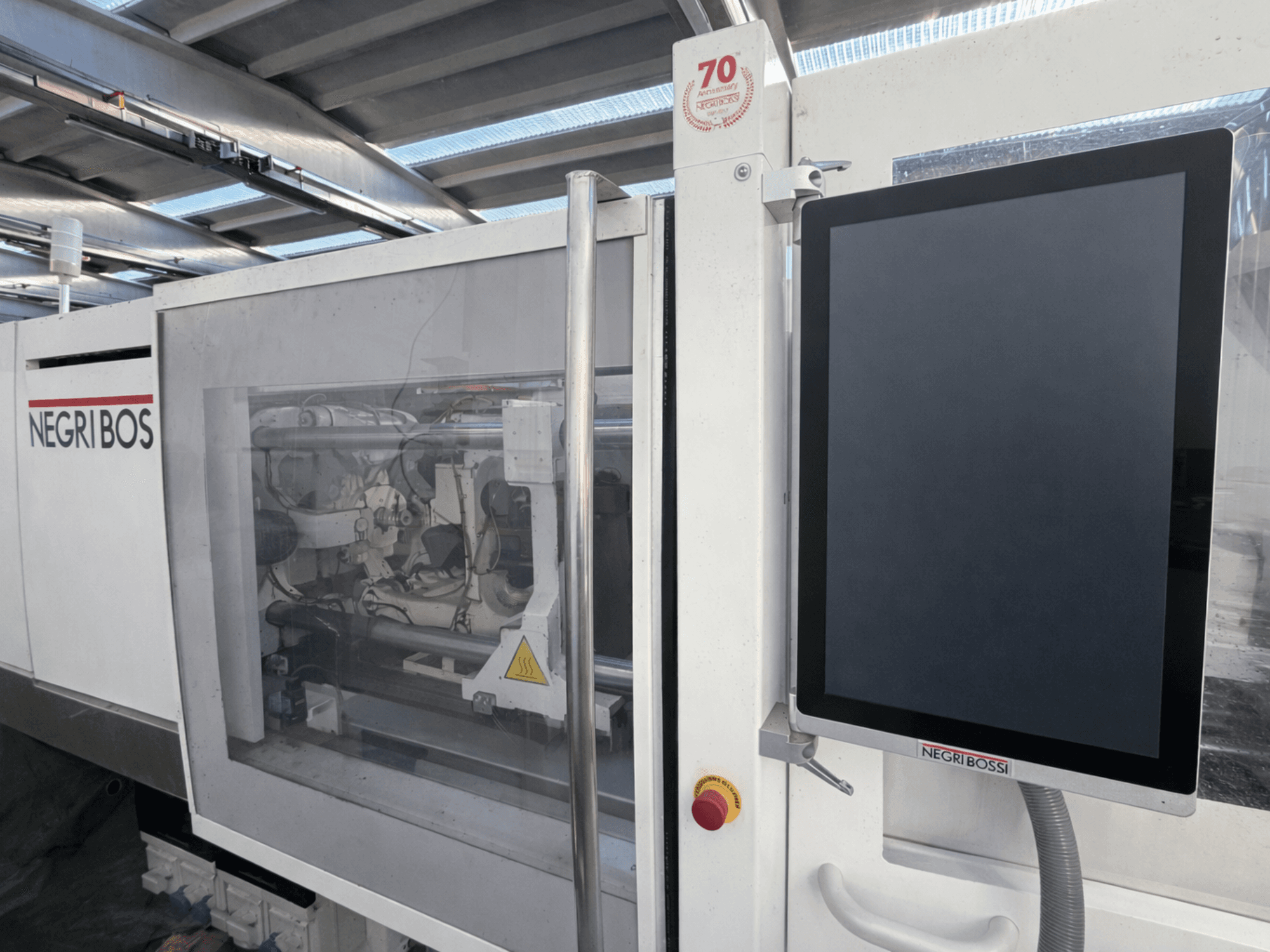 Электрическая машина для литья под давлением Negri Bossi ELE 80, вид спереди с экраном управления и видимыми внутренними компонентами.
