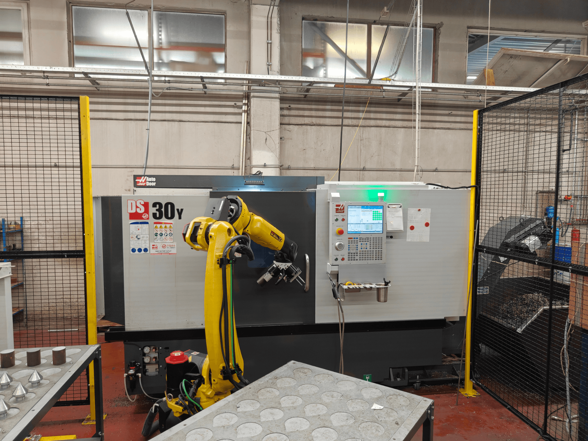 Горизонтальный токарный станок HAAS DS30Y с роботом-манипулятором, вид спереди, на котором видны панель управления и рабочая зона.