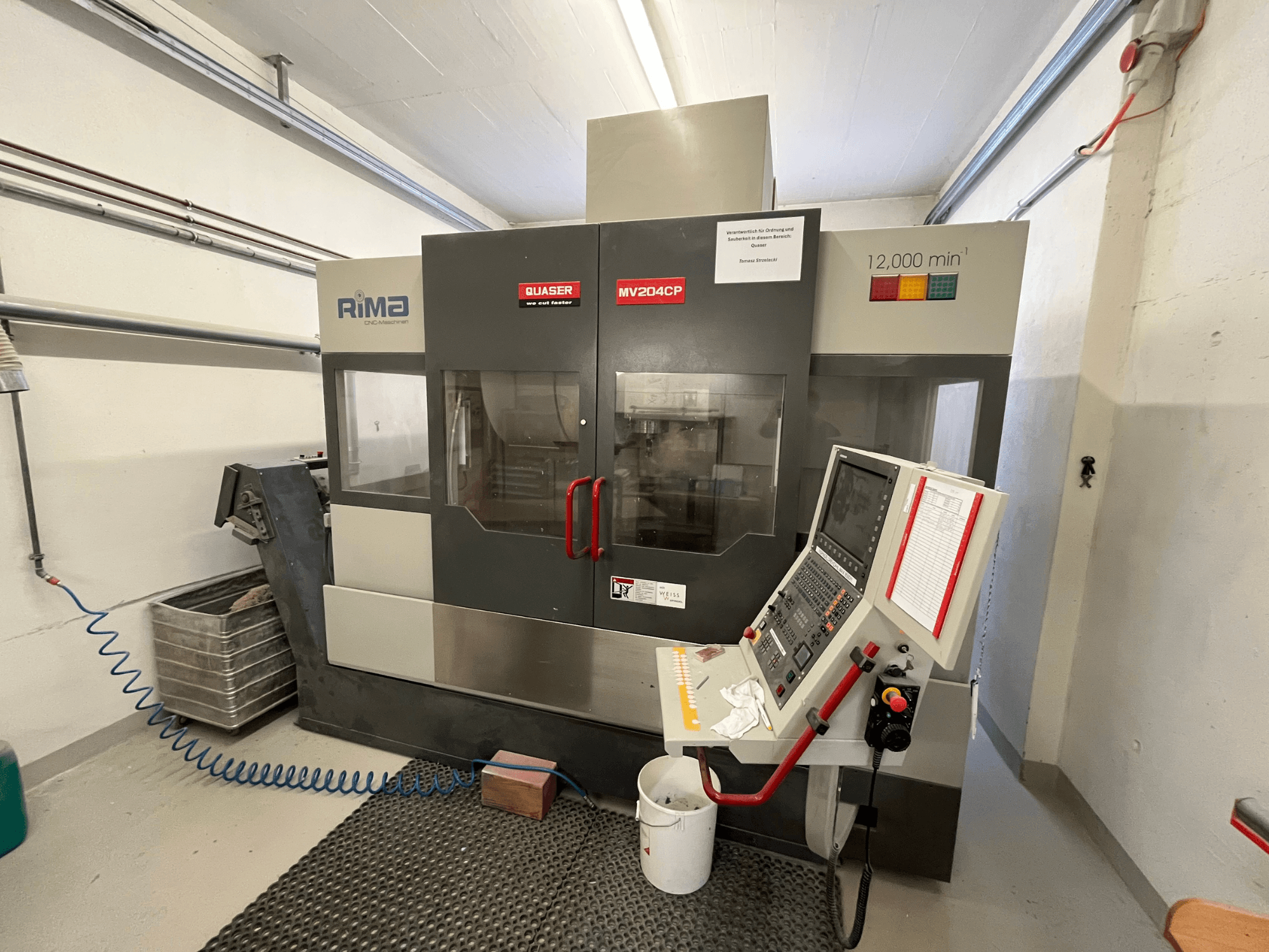 Вертикальный обрабатывающий центр Quaser MV-204 CP вид спереди, панель управления и рабочие детали.