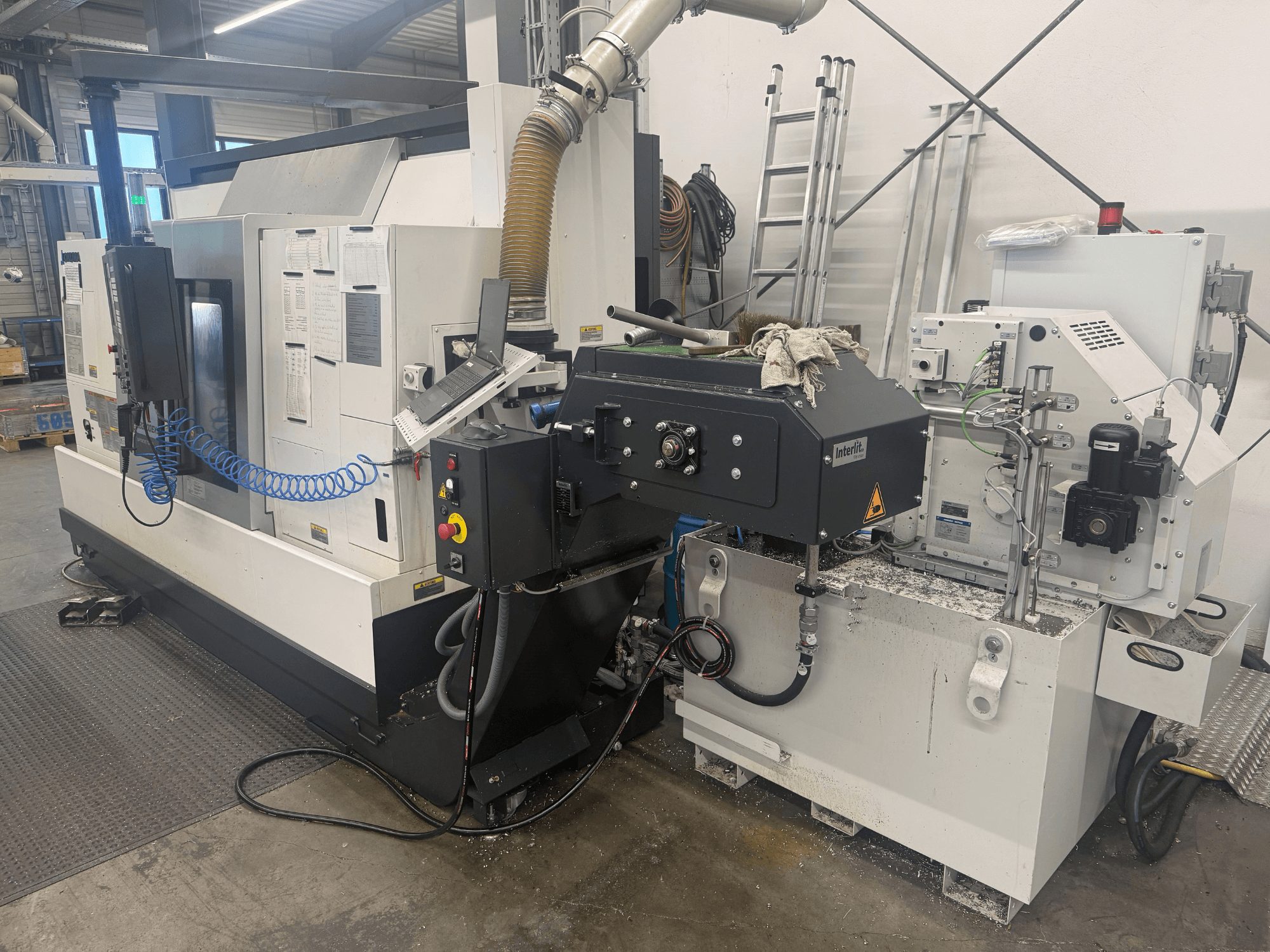Горизонтальный токарный станок Okuma LB3000II-MYC 950, вид спереди, демонстрирует панель управления и систему подачи охлаждающей жидкости.